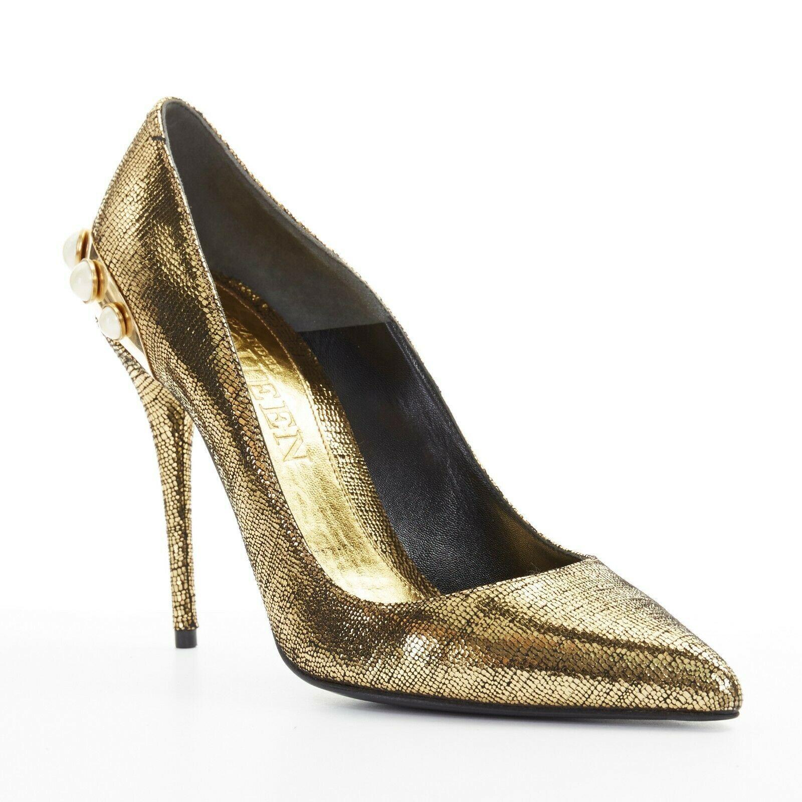 new ALEXANDER MCQUEEN metallic gold leather pearl embellished pointy heel EU38
ALEXANDER MCQUEEN
Metallic gold leather upper. 
Gold-tone metal hardware with faux pearl embellishment at heel. 
Slim high heel. 
Pointed toe. 
Padded gold leather