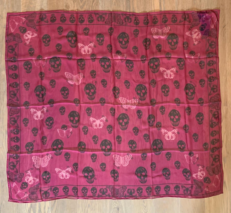 New Alexander McQueen large semi-sheer magenta scarf featuring skull, butterfly, and safety pin print throughout. Rolled edges. Signed Alexander McQueen in logo at bottom corner. 

Purchased directly from an authorized McQueen retailer.

100%