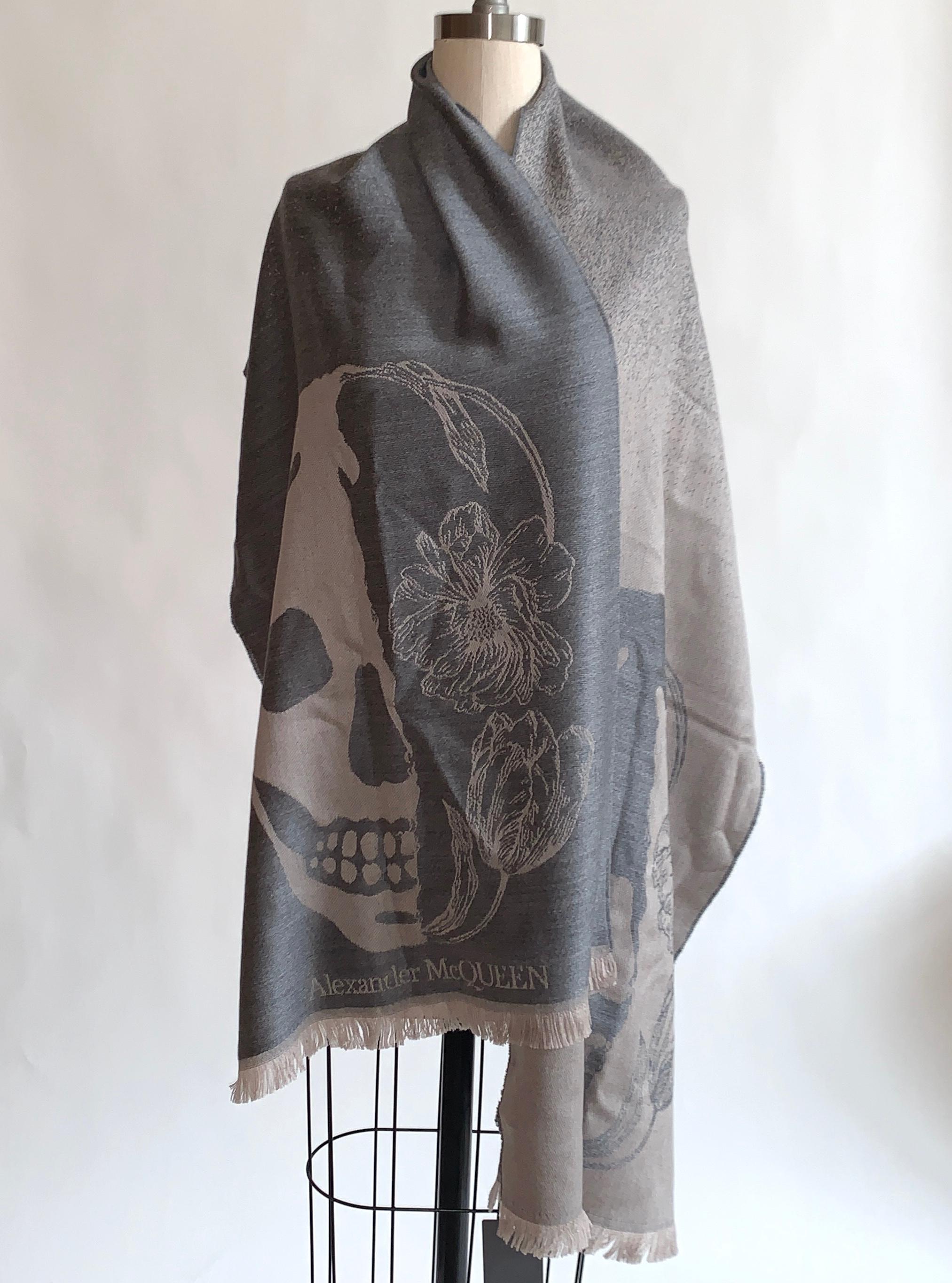 New Alexander McQueen large grey scarf featuring skull and flower print at each end. Super soft wool. Fades from darker grey at one end to lighter at the other. Light fringe at ends. Signed Alexander McQueen at one bottom corner.

Purchased directly