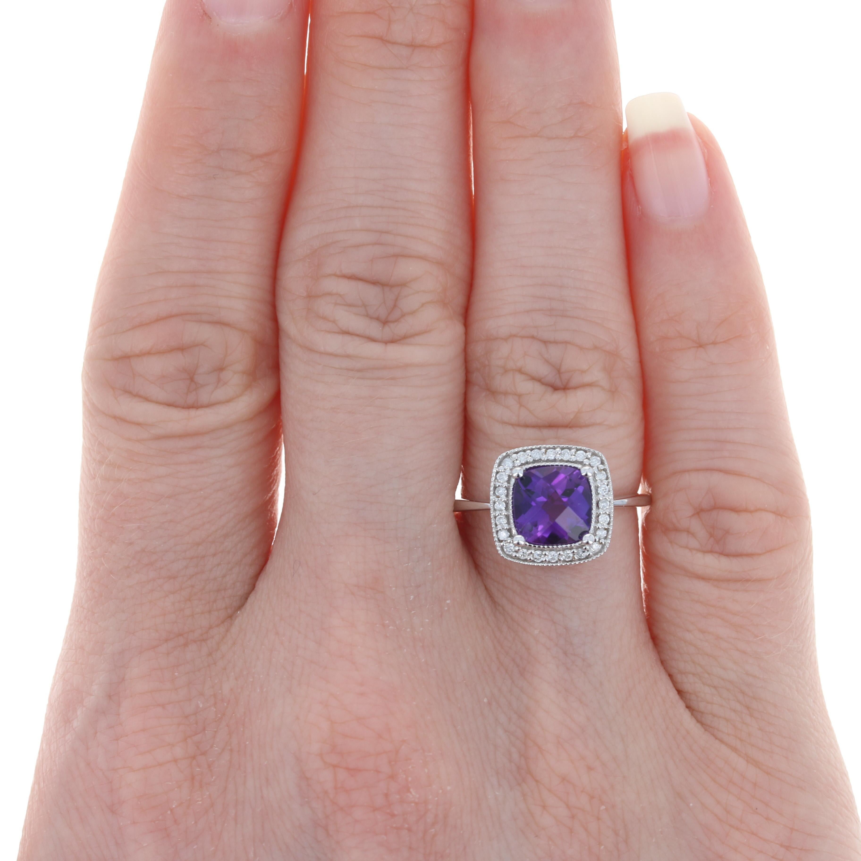 Add a brilliant pop of color to your attire with this gorgeous ring! Fashioned in 10k white gold, this NEW piece showcases a vivacious amethyst solitaire surrounded by a shimmering halo of white diamonds which are outlined by beautiful milgrain