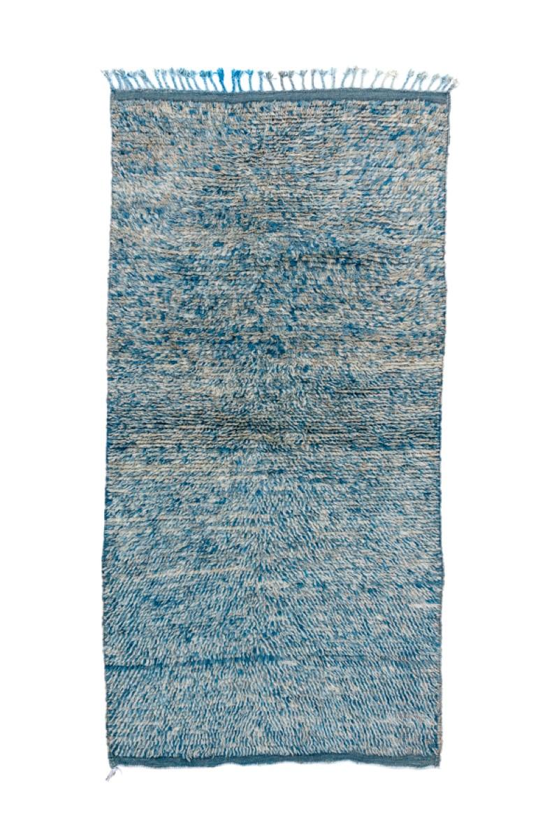 All abrash, in shades of pale blue, with a narrow partial band of a somewhat darker blue. The flatwoven ends are in a slightly darker shade of blue. Blue tassels. Coarse weave, as new condition. A monochrome with knot by knot colour