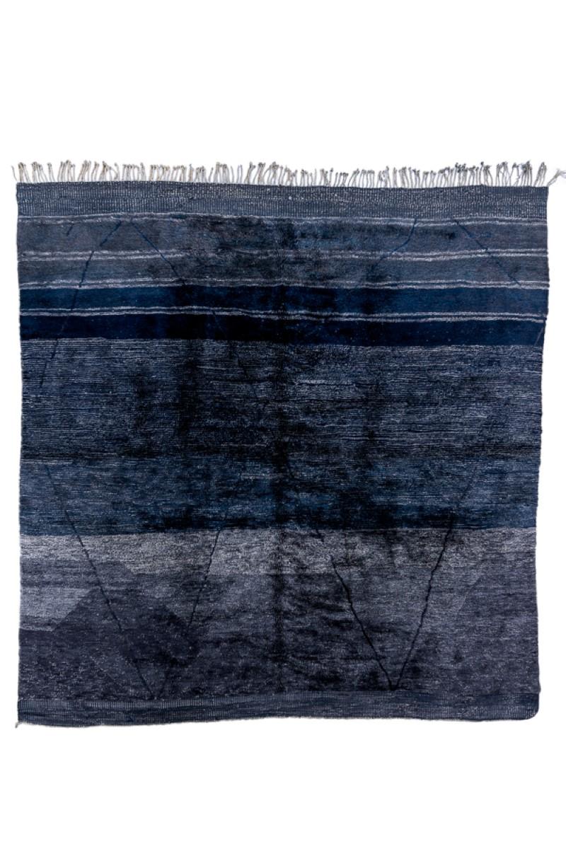 In panel abrashed indigo with five darker stripes across one end colliding with a tall, etiolated double lozenge pattern. Unusual format. The abrash here provides another pattern,. Note especially the hexagon at lower left. Full pile and coarse
