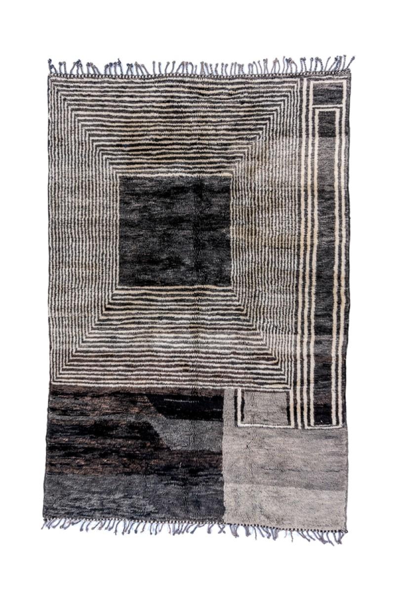 In an Art Deco style with a minimal and greys, with an eccentric layout of squares and lines running up and down and across, with beveled right angle joins. The abrash in one panel helps to count the weavers, two or three in all. Lush pile. Coarse