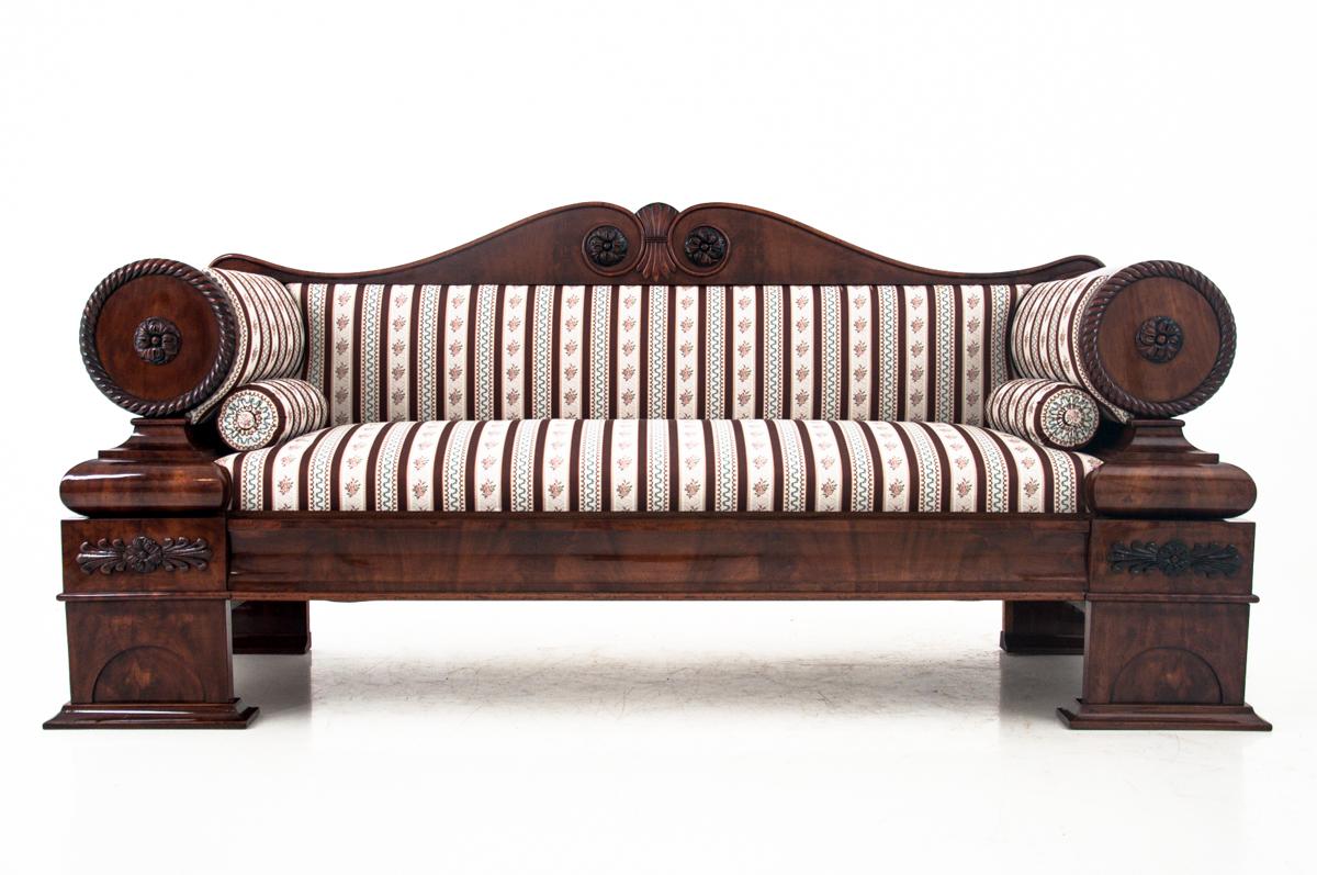 Biedermeier style sofa after the complex process of wood and upholstery renovation. This unique piece comes from West Europe and it's dated circa 1840. Round armrests finished with carved medallions and a simple stile create a unique form.