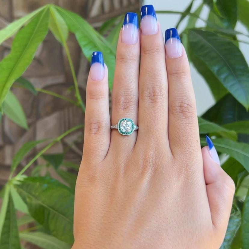One Art Deco Inspired 1.29 Carats Old Mine Cut Diamond Emerald Platinum Ring. Featuring one old mine cut diamond of 1.29 carats, graded J color, SI clarity. Accented by 24 calibré cut emeralds with a total weight of approximately 0.75 carat, and six