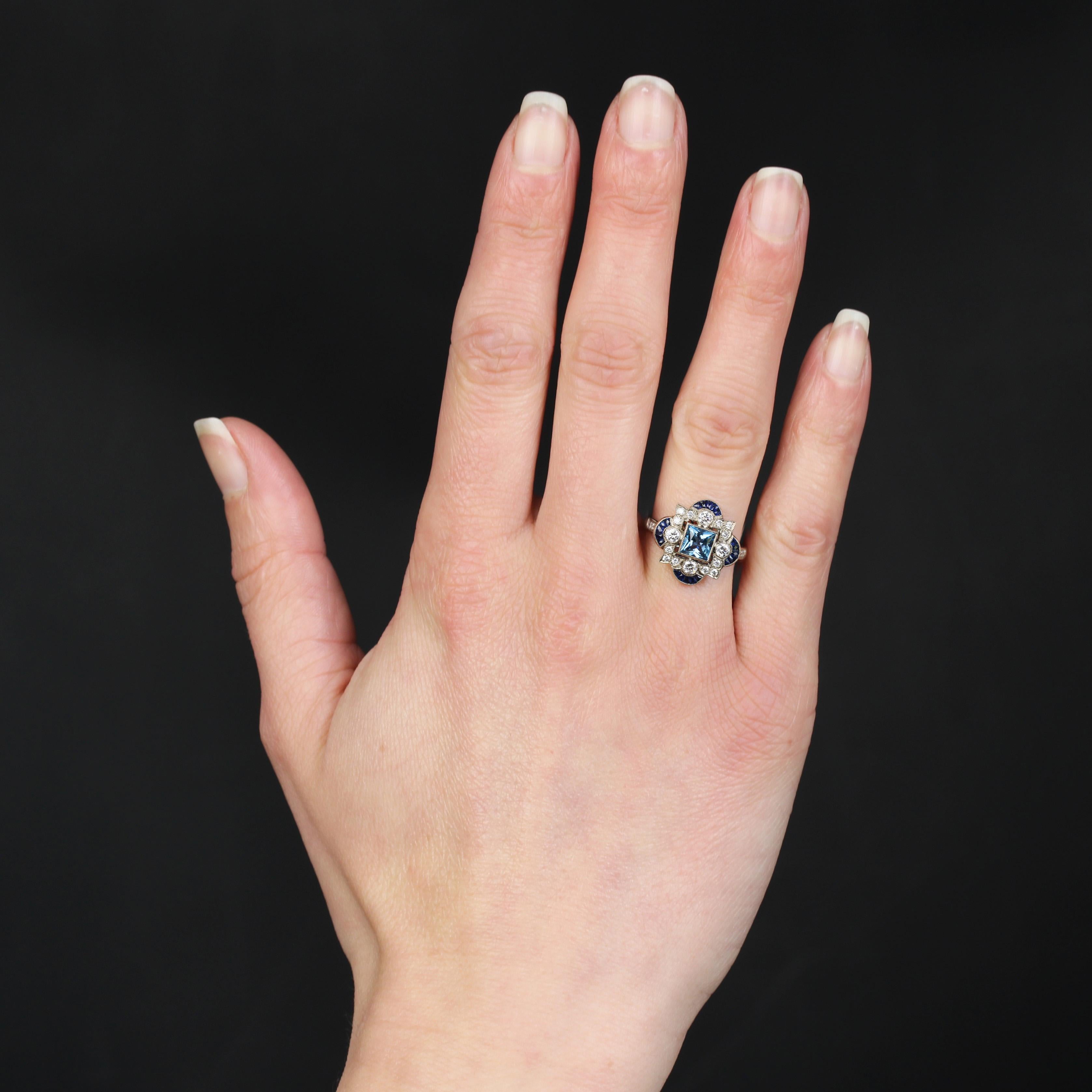 Ring in 18 karat white gold.
This Art Deco-style ring is set with a square aquamarine in millegrain closed setting in the center of an openwork design set with modern brilliant-cut diamonds in millegrain setting. At each cardinal point of the
