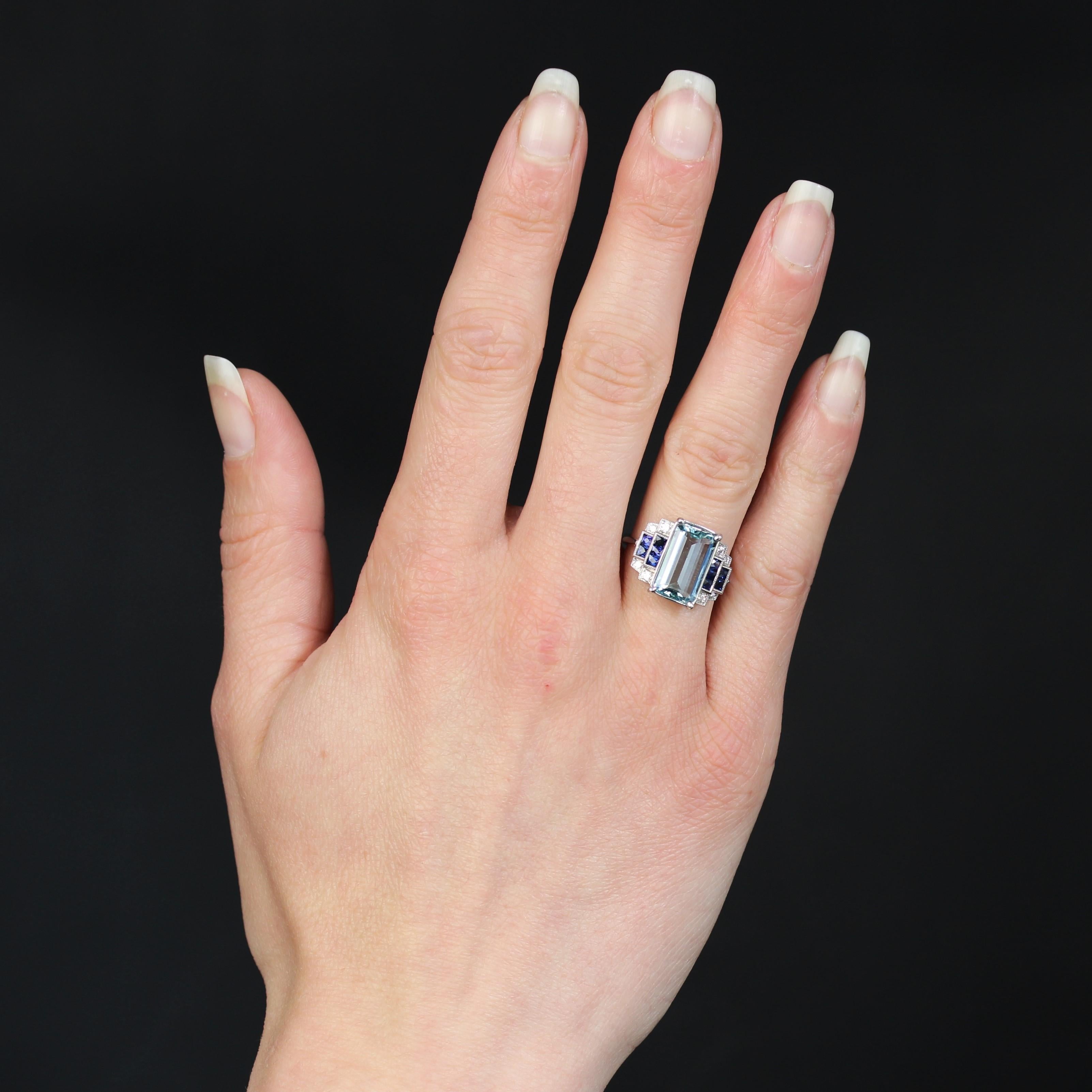Anello in oro bianco 18 carati, marchio di fabbrica con testa d'aquila.
Riprendendo i codici dei primi anelli Art Decor, questo anello in oro bianco presenta un'incastonatura con decorazioni a gradini e millegradi. Al centro, un'acquamarina tagliata