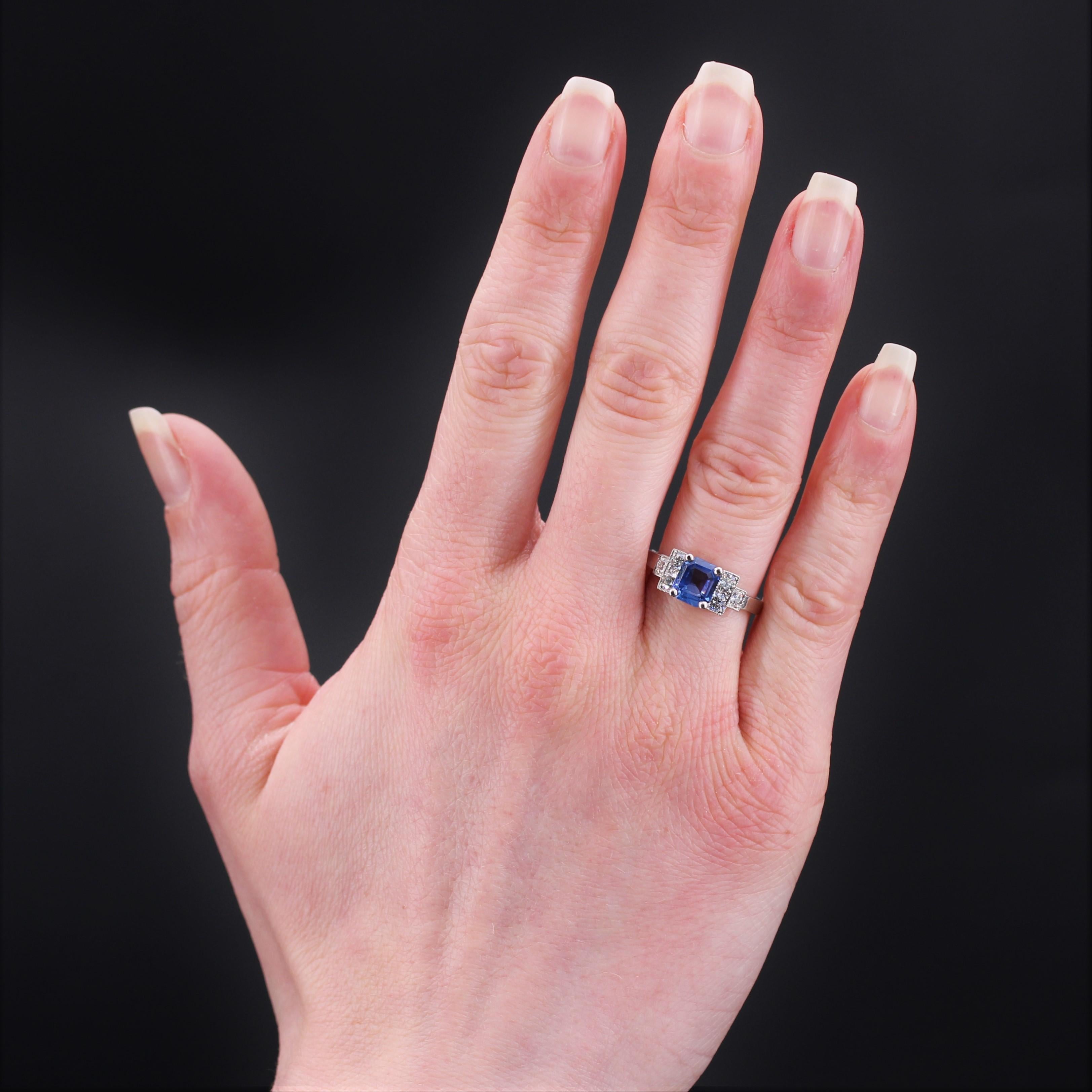 Ring in platinum, dog head hallmark.
Charming art deco style ring, it is set with an emerald- cut sapphire set with four claws and shouldered on both sides with 2 x 3 modern brilliant- cut diamonds, on a staircase pattern.
Weight of the sapphire :