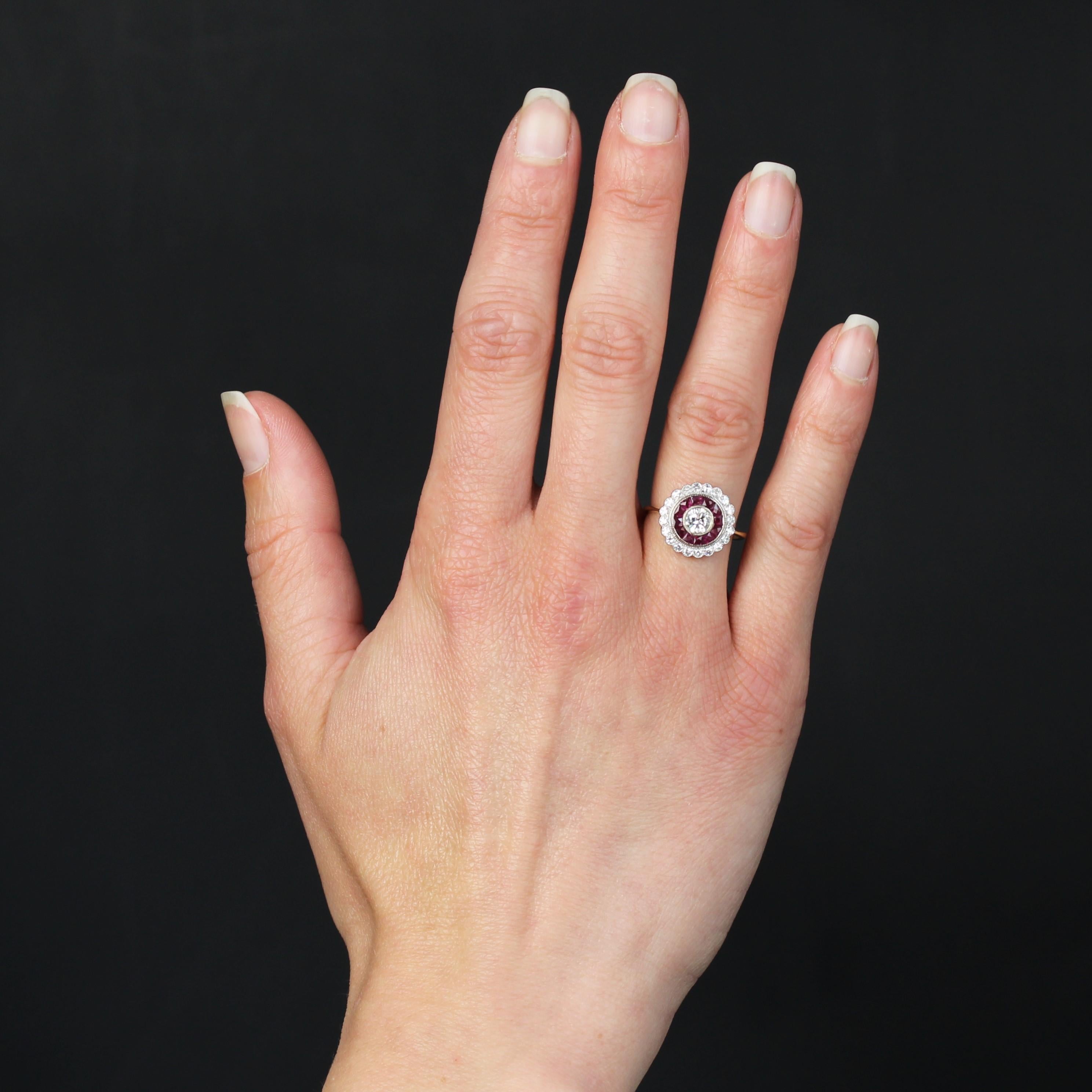 Ring in 18 karat white and yellow gold.
In the spirit of vintage Art Deco rings, this ravishing ruby-diamond ring is round in shape. It is successively set with a brilliant-cut millegrain diamond, calibrated millegrain rubies and scallop-set 8/8-cut