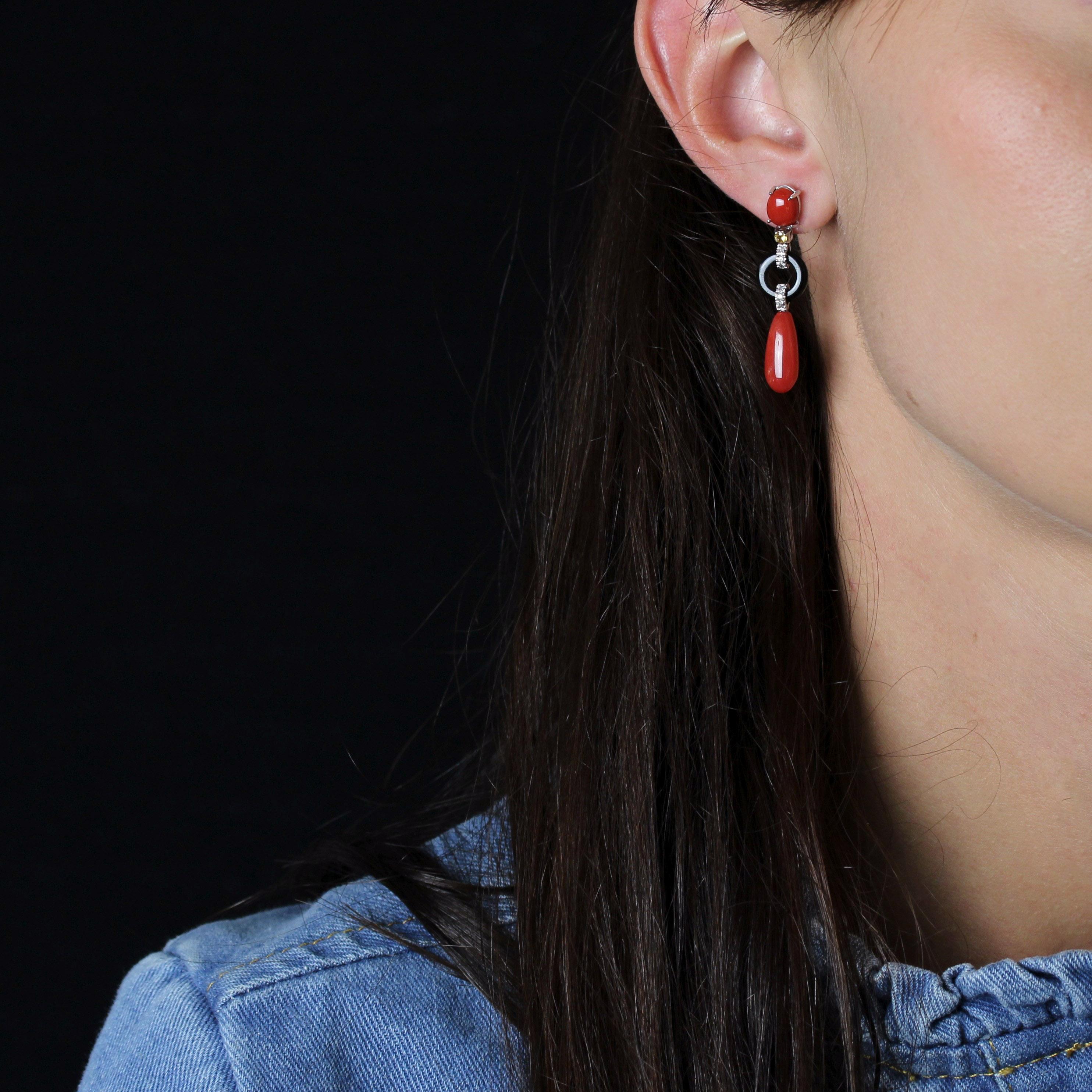 Para orejas perforadas.
Pendientes de oro blanco de 18 quilates.
Cada pendiente de oro blanco presenta un cabujón ovalado de coral sujeto por cuatro garras, que sostiene un motivo formado por un engaste que sostiene un diamante amarillo talla