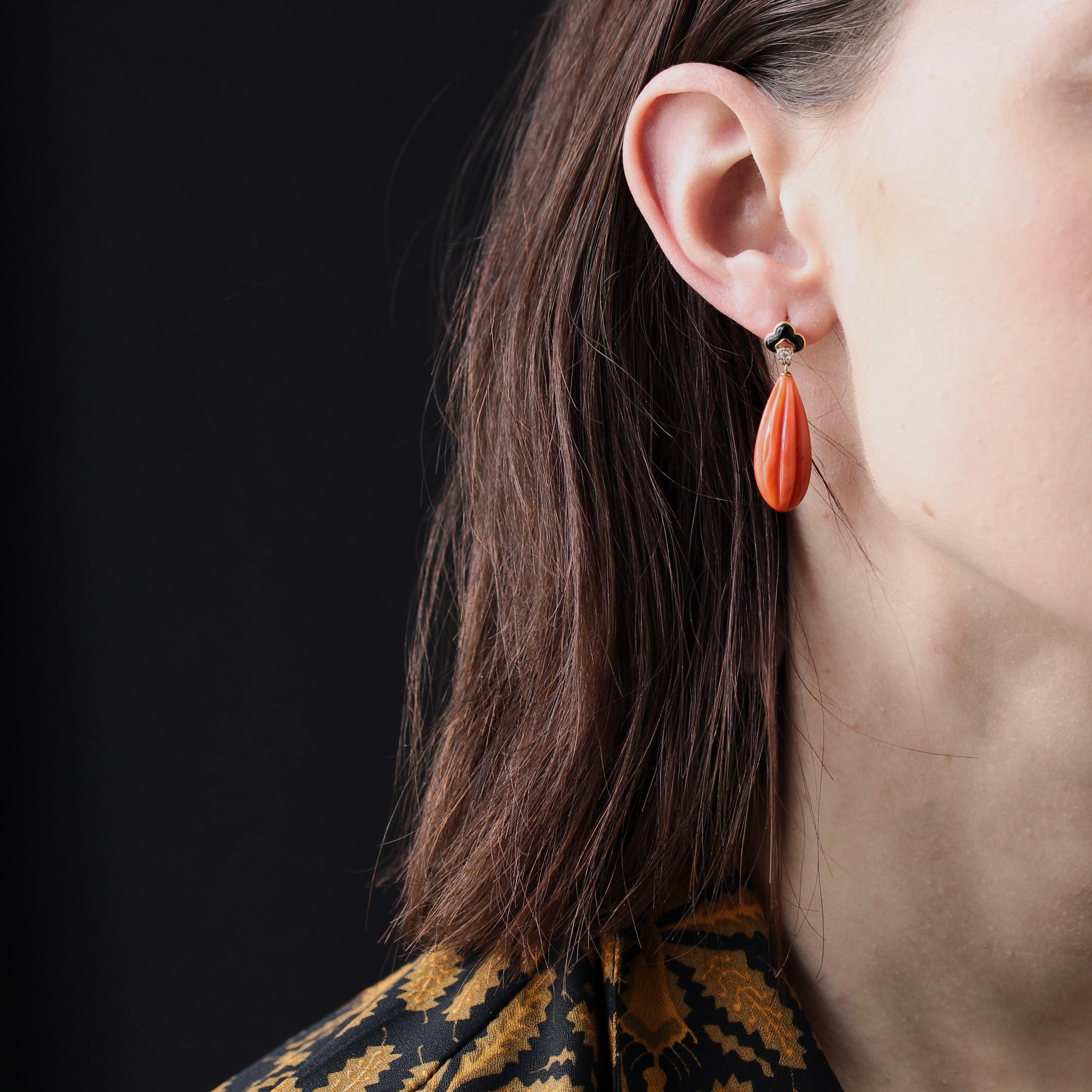 For pierced ears.
Earrings in 18 karat yellow gold.
In the style of Art Deco earrings, these earrings feature a polylobed motif adorned with cabochon onyx and 7 modern brilliant-cut diamonds. A drop of gadrooned coral is attached as a tassel. The