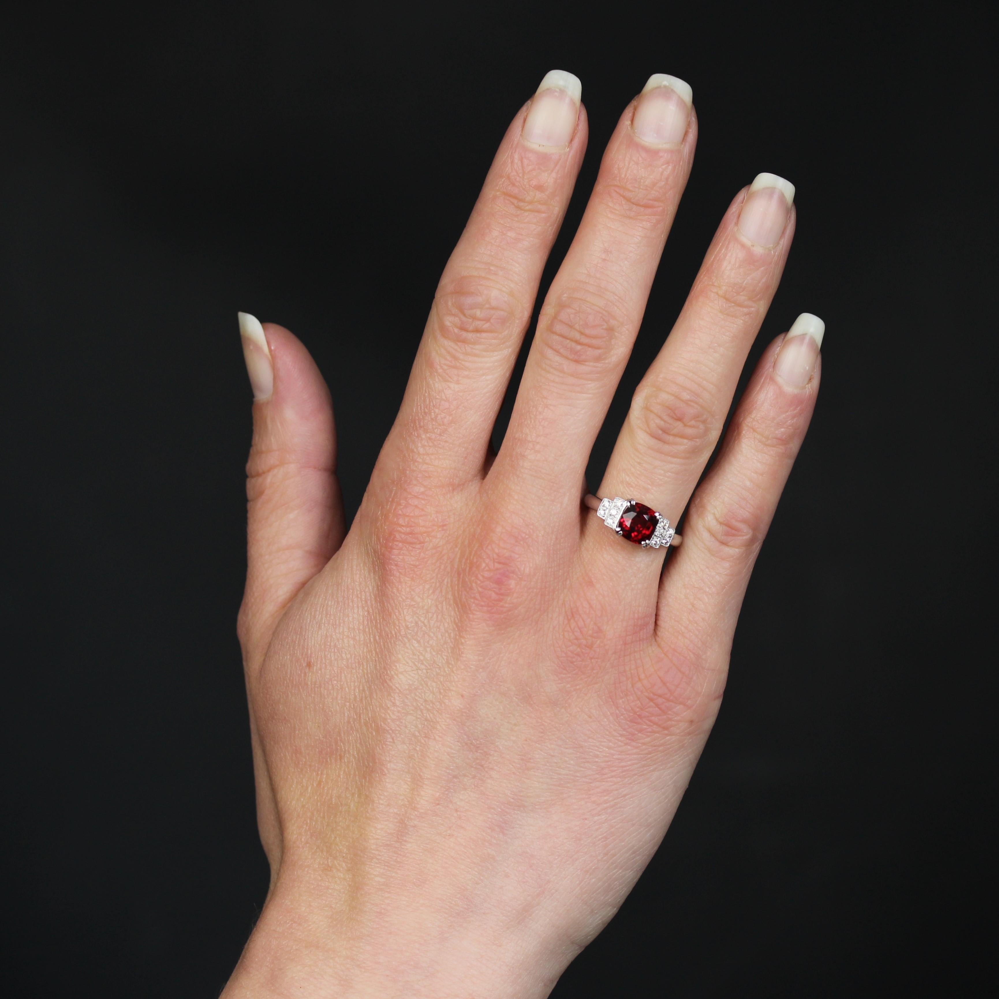 Bague en or blanc 18 carats, poinçon tête d'aigle.
Dans l'esprit des bagues anciennes de style Art déco, cette monture intemporelle en or blanc présente au centre un spinelle rouge naturel certifié, retenu par des griffes 4x2. De chaque côté, serti
