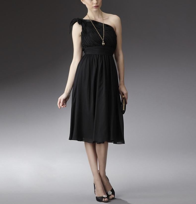 Abito da cocktail di Badgley Mischka
Nuovo di zecca con etichette
Dimensione: 4
* 100% seta
-	Abito in seta nera con dettagli di perline e ruche
-	Circa 40 cm dalla spalla all'orlo
-	Monospalla con scollo obliquo di perline 
-	Fiocco decorativo in