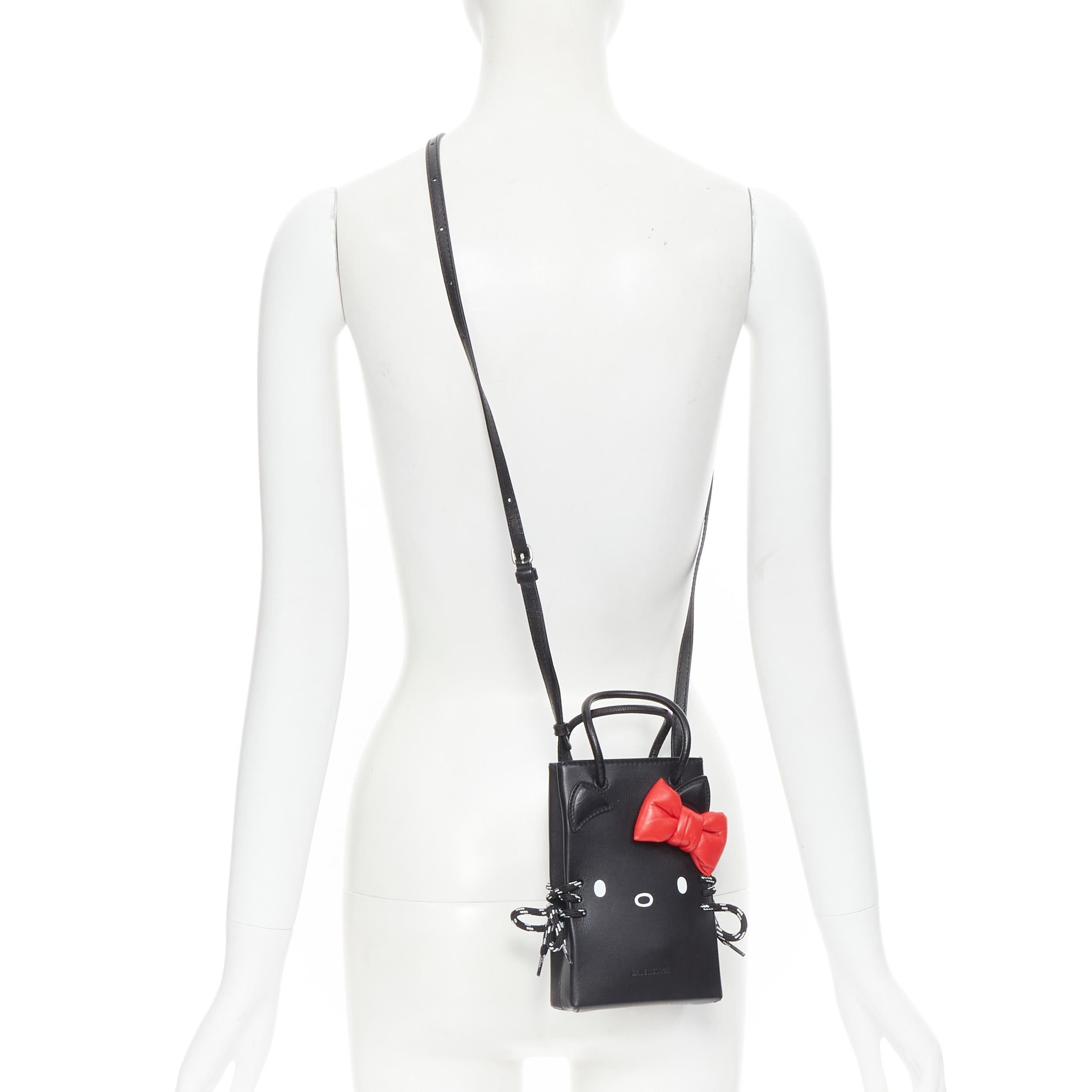 new BALENCIAGA Kitty Phone Holder red bow black leather micro crossbody bag 
Reference: TGAS/B01533 
Brand: Balenciaga 
Designer: Demna Gvasalia 
Model: Kitty phone holder Collection: Sanrio Hello Kitty Runway 
Material: Leather 
Color: Black