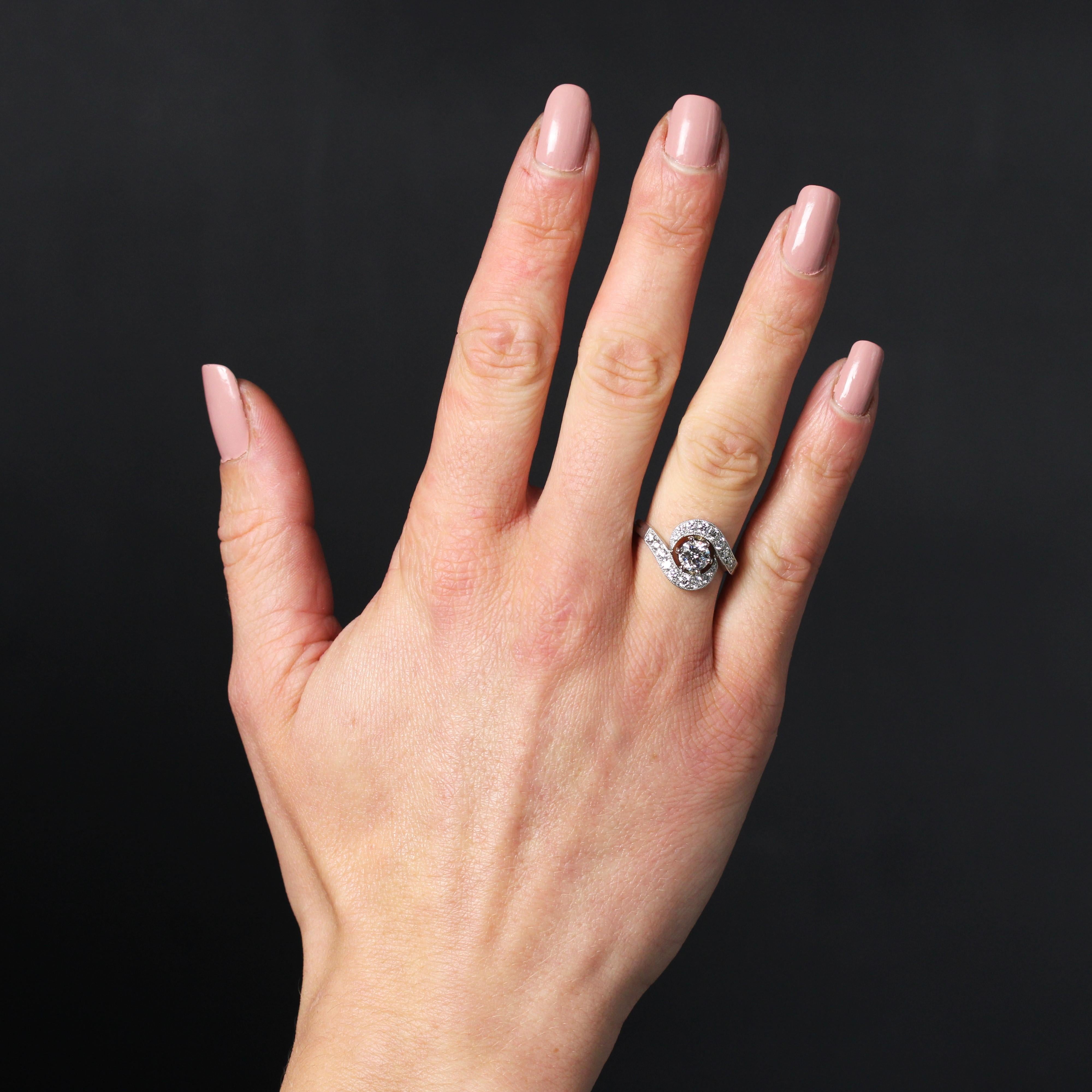 Ring in platinum, dog head hallmark, and 18 karat white gold, eagle head hallmark.
Elegant diamond ring, its setting forms a swirl on the top of the finger, set with modern brilliant-cut diamonds and within a millegrain. In the center, a modern
