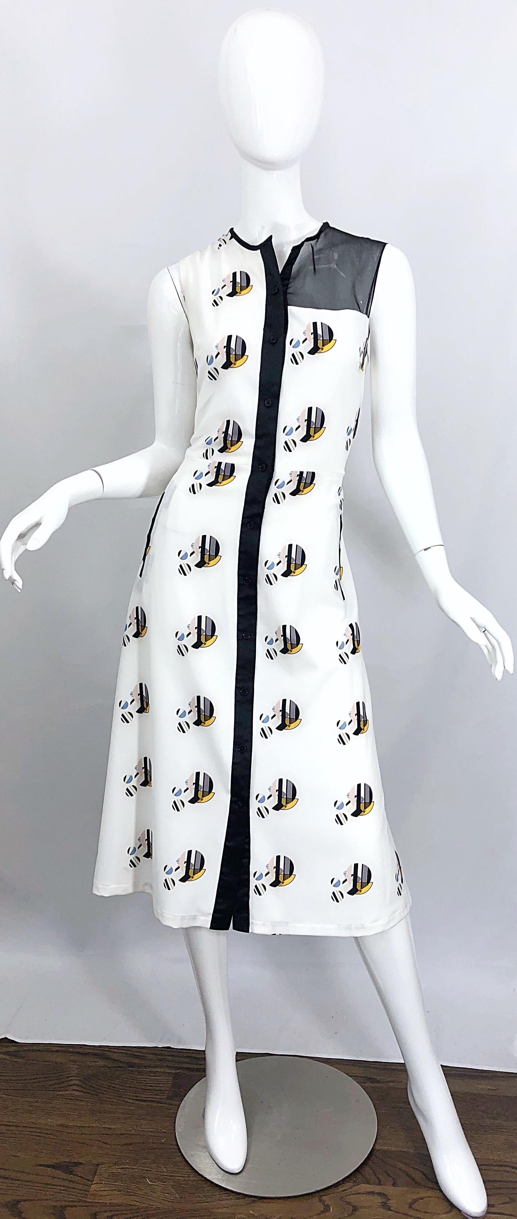 Chic brand new BIBHU MOHAPATRA abstract printed silk sleeveless shirt dress! Features a crisp white silk with abstract circle shapes in vibrant colors of blue, yellow, taupe and black. Black sheer panel at left shoulder and top back. Hidden buttons