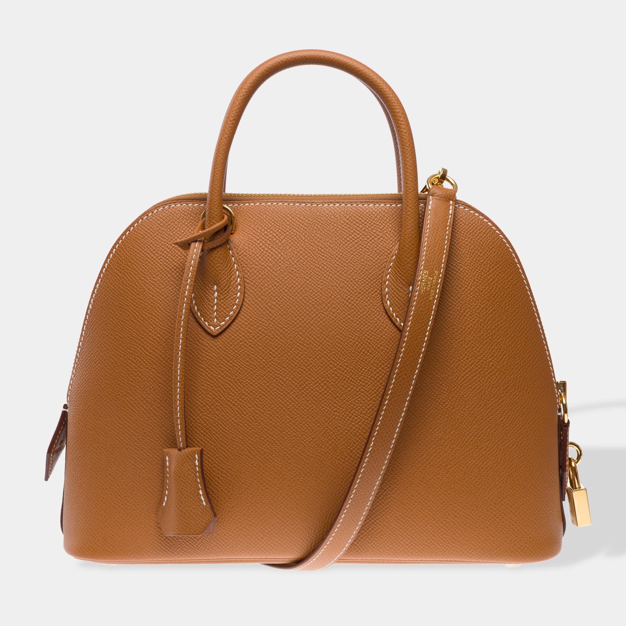 Beautiful​ ​Hermès​ ​Bolide​ ​25cm​ ​1923​ ​handbag​ ​strap in​ ​Epsom​ ​Gold​ ​leather,​ ​with​ ​gold​ ​metal​ ​hardware,​ ​removable​ ​shoulder​ ​strap​ ​and​ ​double​ ​leather​ ​handles​ ​allowing​ ​for​ ​hand,​ ​shoulder,​ ​or​ ​crossbody​
