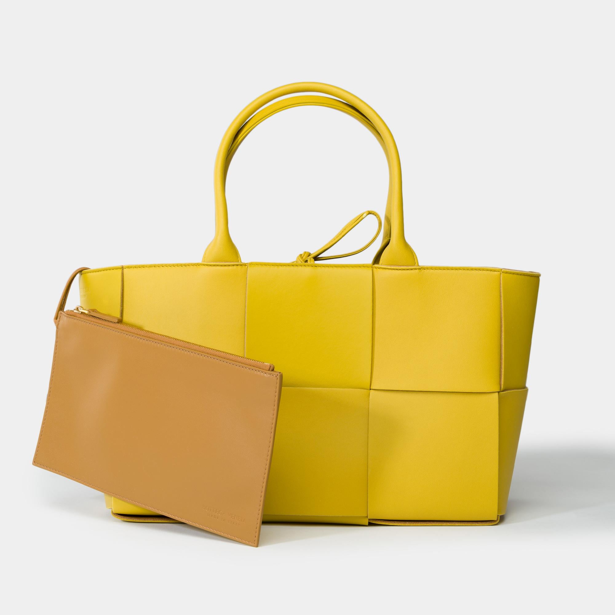 Bellissima borsa Bottega Veneta Arco Tote in pelle d'agnello intrecciata Yellow Intrecciato, finiture in metallo dorato
Si chiude con un cinturino in pelle
Interni in pelle nocciola
All'interno c'è uno scomparto principale in pelle marrone con una