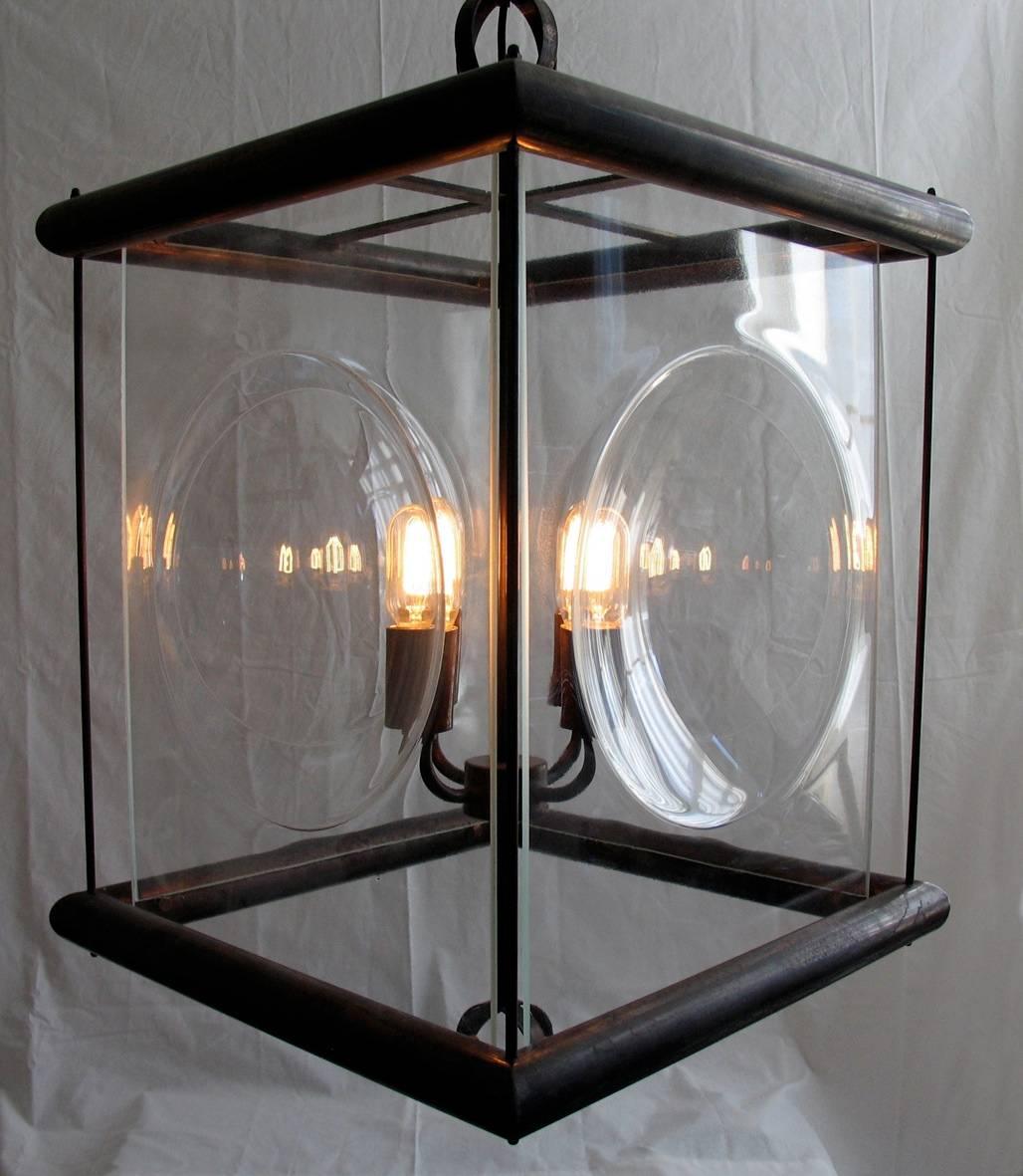 A timeless pendant lantern of brass tubing with a Rustic Bronze finish and slumped glass semi-sphere panels. Two spherical finials finish the design. 
The glass can be set as 'concave' or 'convex' 
Four E26/E27 light bulb holders. Includes 24