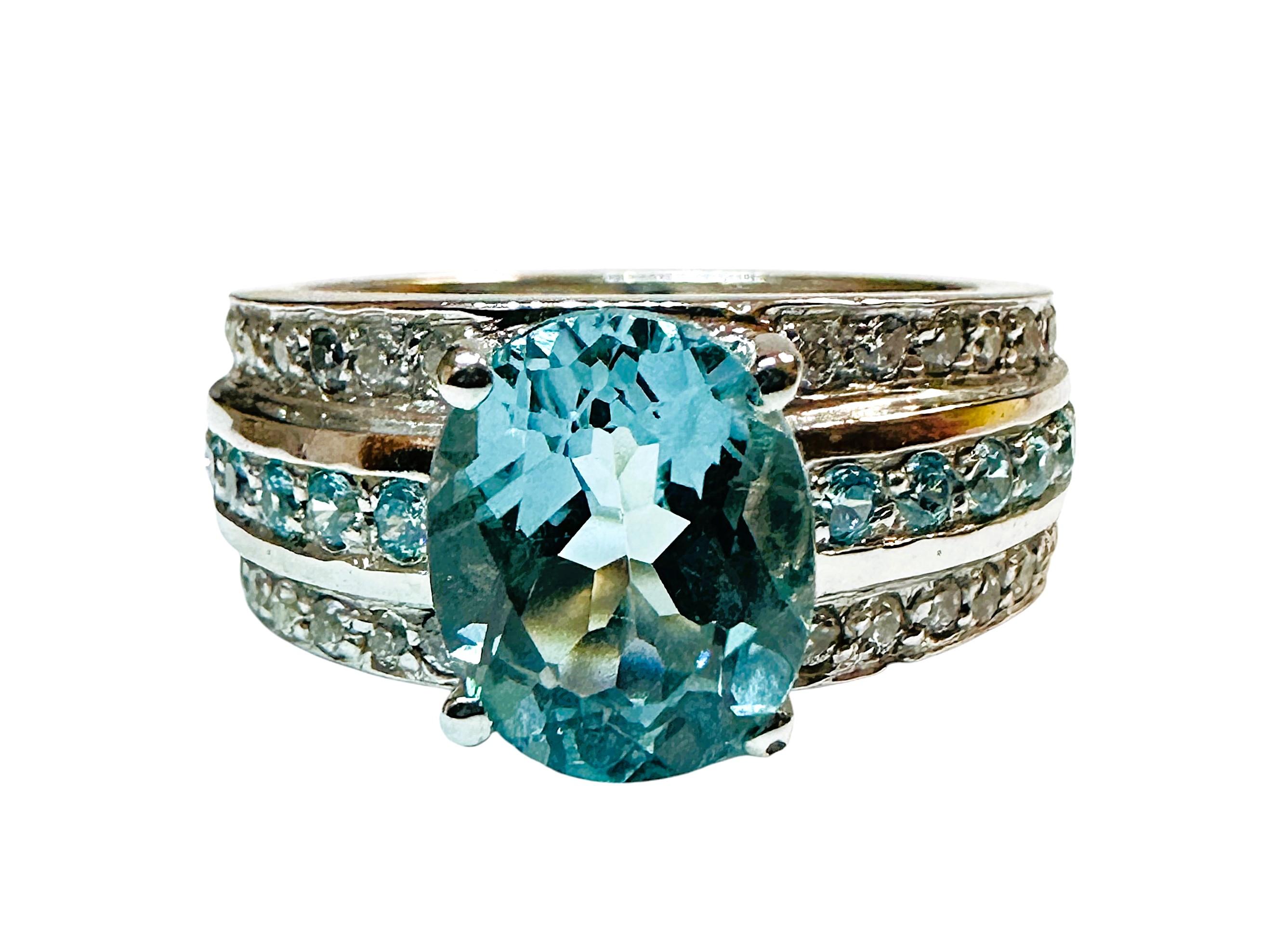 La piedra es de Brasil y es simplemente exquisita. La piedra es una aguamarina azul hielo de 2,60 quilates.  La piedra es de talla ovalada, mide 10 x 8,2 mm y tiene 3 filas de zafiros talla diamante que recorren la banda.  La fila central es de