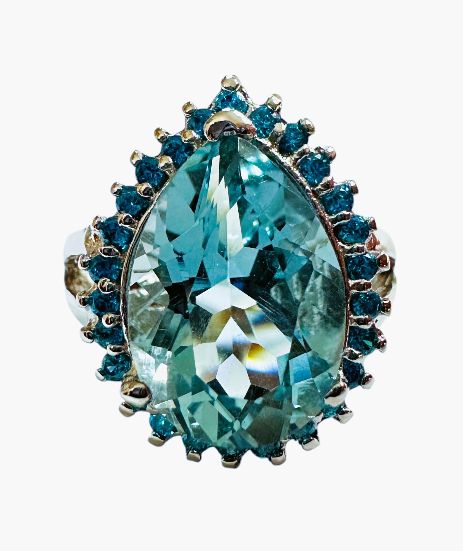 The stone is from Brazil and is just exquisite. The stone is a sea blue aquamarine and is 5.55 cts.  The stone is a pear cut stone and measures 14 x 10 mm and is surrounded by diamond cut blue sapphires which really compliments the ring  It is