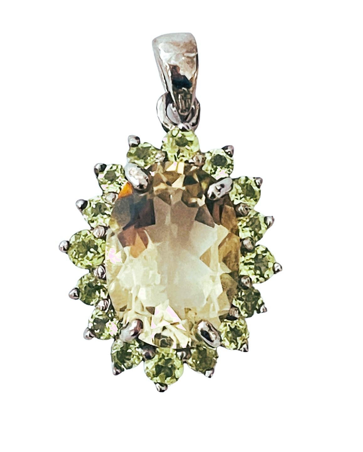 This pendant is just so beautiful!  The stone is from Brazil and is just exquisite.  It is an oval cut and is 5.81 Ct   The main stone is 14 x 10 mm and is surrounded by diamond cut green Peridot stones. The pendant itself is 1.13 inch long and .68