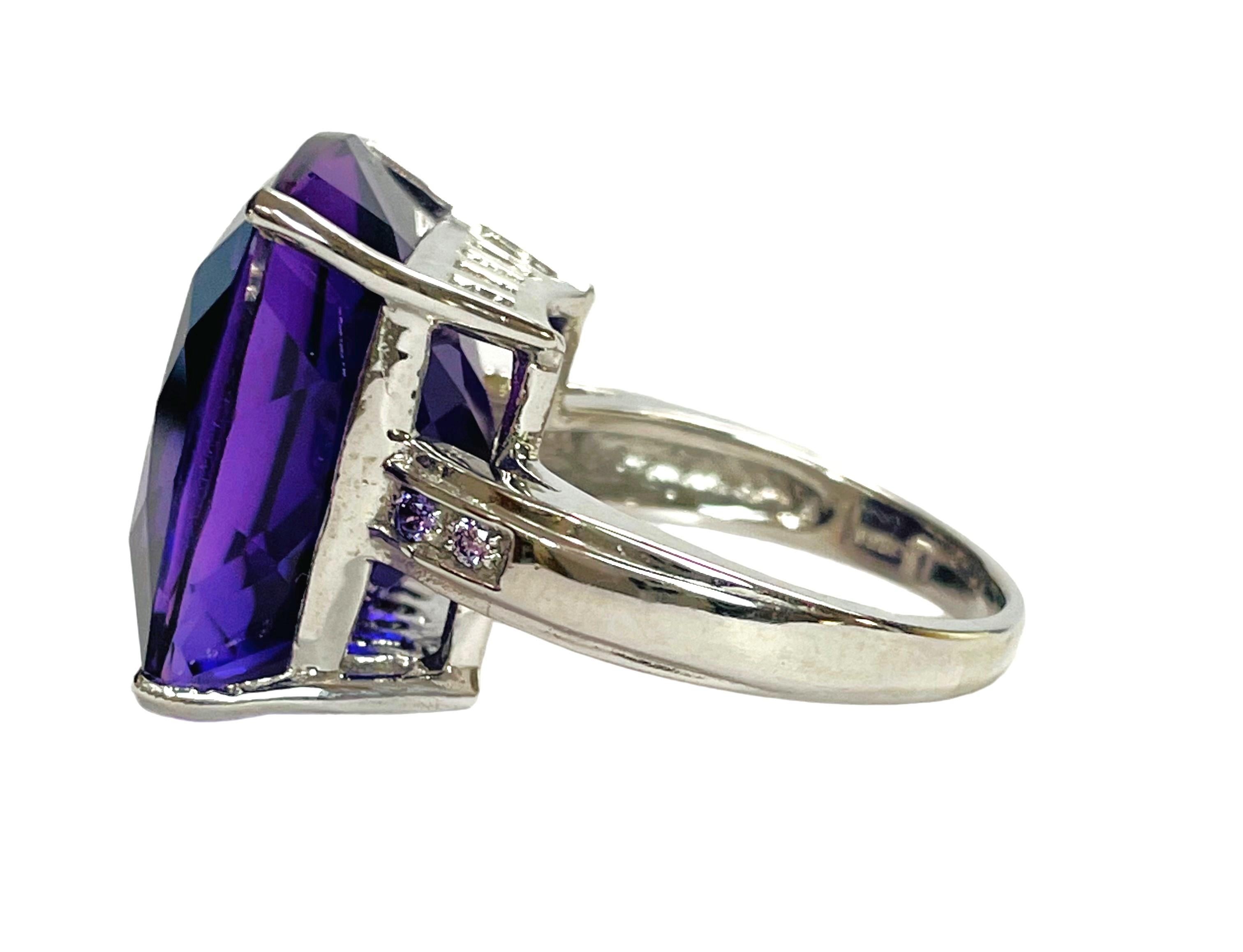 This stone was mined in Brazil..  It is a rich 2 color Stone with beautiful hues of blues and purples..  It is a beautiful cushion cut and is 18.5 mm. It is flanked by a small purple amethyst stones on either side and it is just gorgeous!     Sure