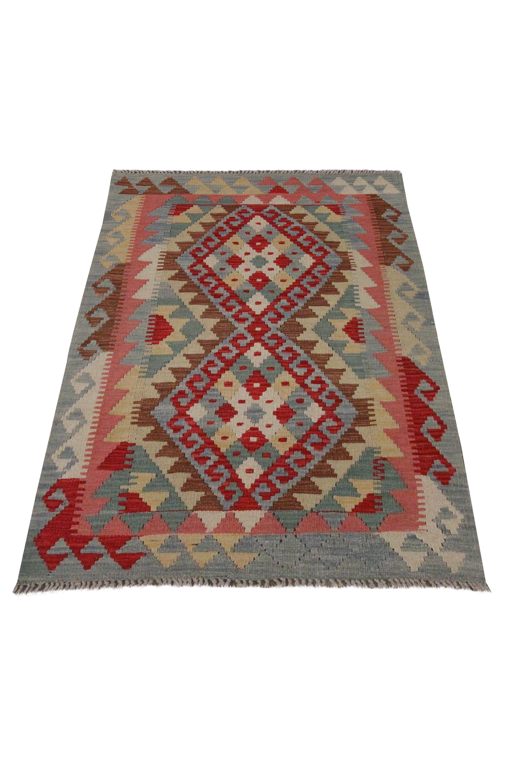 A bold geometric design has been woven in this fine wool kilim rug. Constructed in the early 21st century, in Afghanistan. It features a bold colour palette with accents of red, beige and blue. The bold geometric design, pattern and colours in this