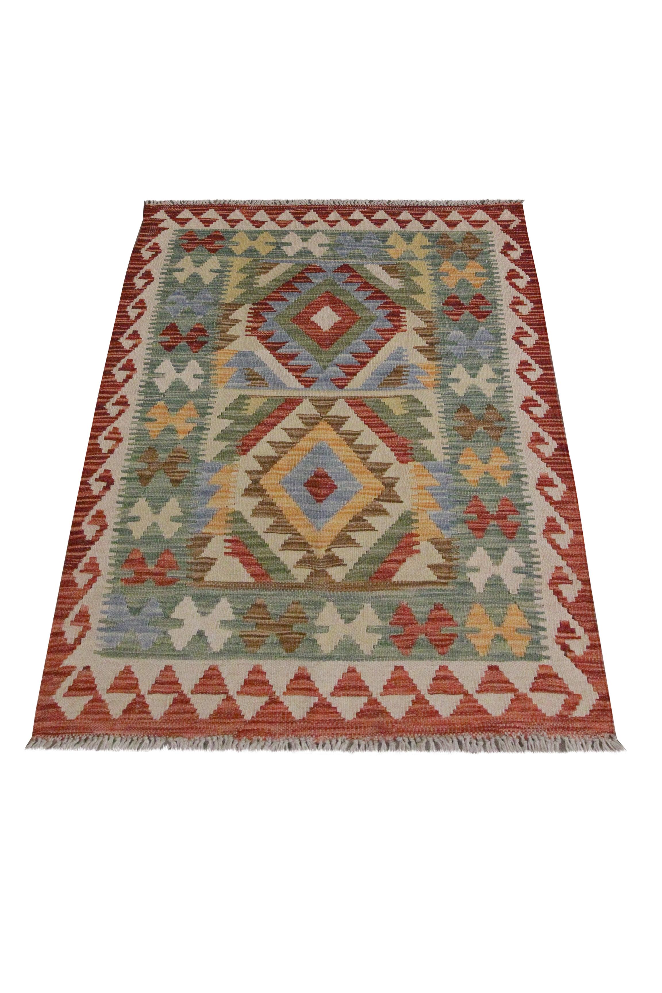 This fantastic kilim is a traditional piece woven in the early 21st century, circa 2015. The design features a typical geometric pattern with a bold colour palette of red, green and beige. The colours and design work in harmony to create this