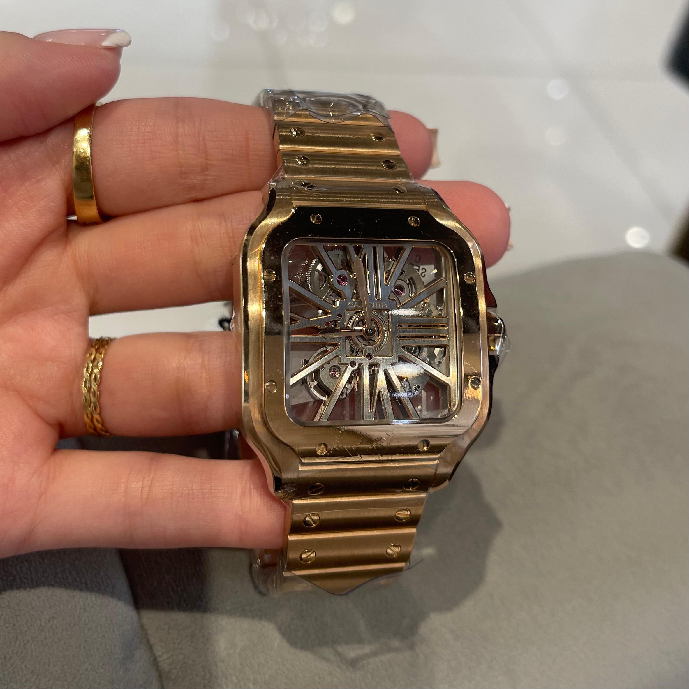 Brand: Cartier

Style: Large Skeleton Watch

Model Name: Santos De Cartier

Model Number: WHSA0016

Movement: Hand-Wound Mechanical Movement

Case Size: 39.7 mm

Year: 2021

Dial Color:  Clear​​​​​​​

Case Material: 18K Rose Gold

Hour Markers: