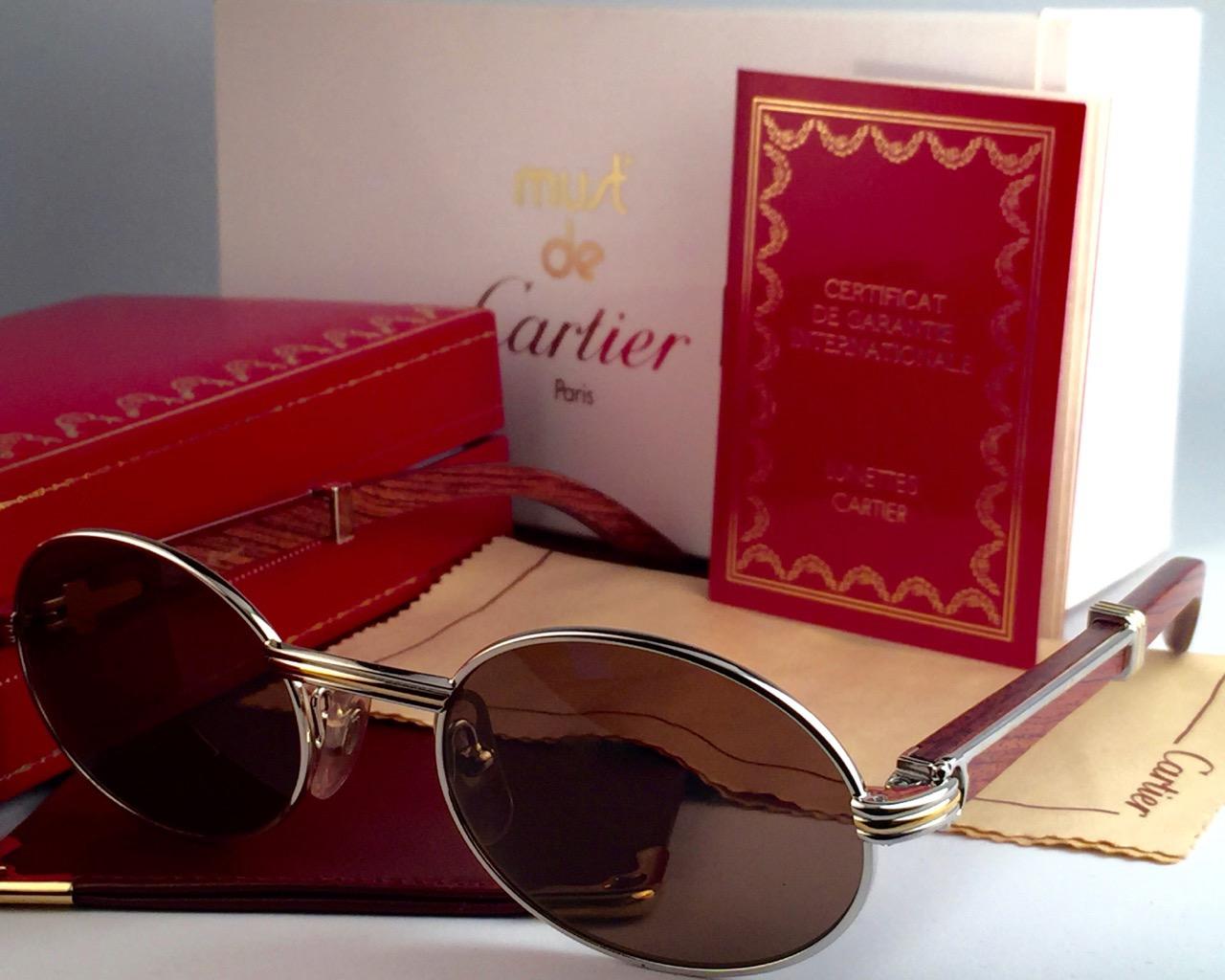 New and very rare original 1992 Cartier Giverny full platinum sunglasses with rosewood temples and brown (uv protection) lenses. 
Frame with the front and sides in platinum.
All hallmarks. 
Gold cartier signs on the ear paddles. Both arms sport the