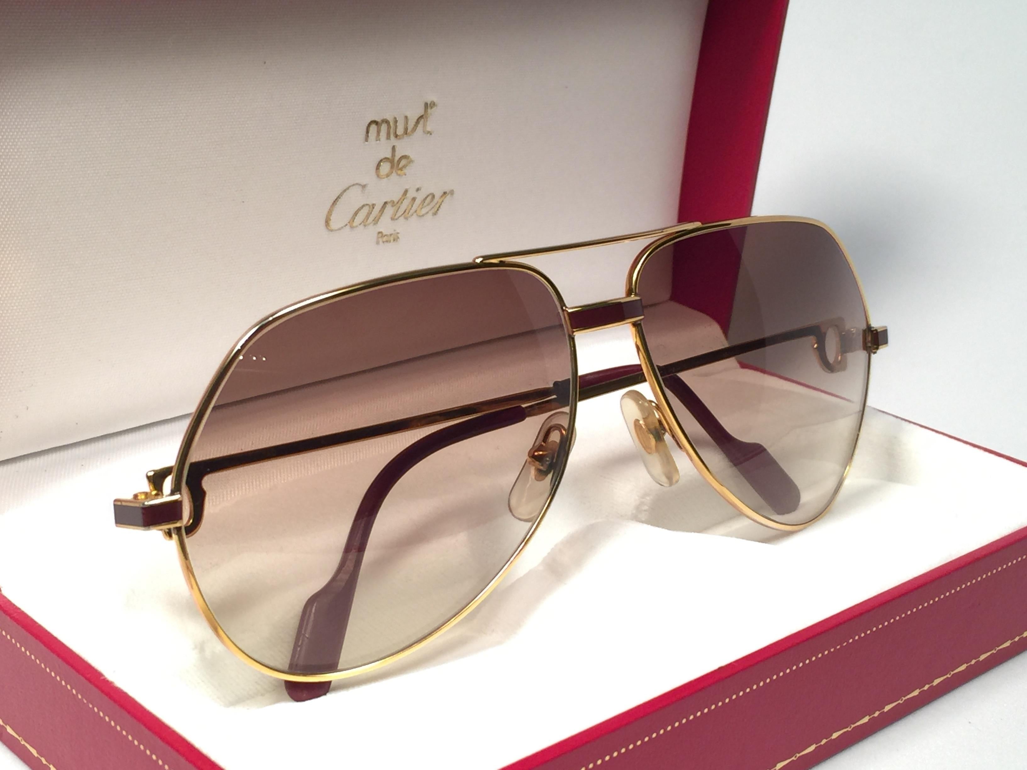 New from 1983!!! Cartier Aviator Laque de Chine Heavy plated gold sunglasses with brown gradient  (uv protection) Lenses.
All hallmarks. 
Red enamel with Cartier gold signs on the ear paddles. 
Both arms sport the C from Cartier on the temples.
