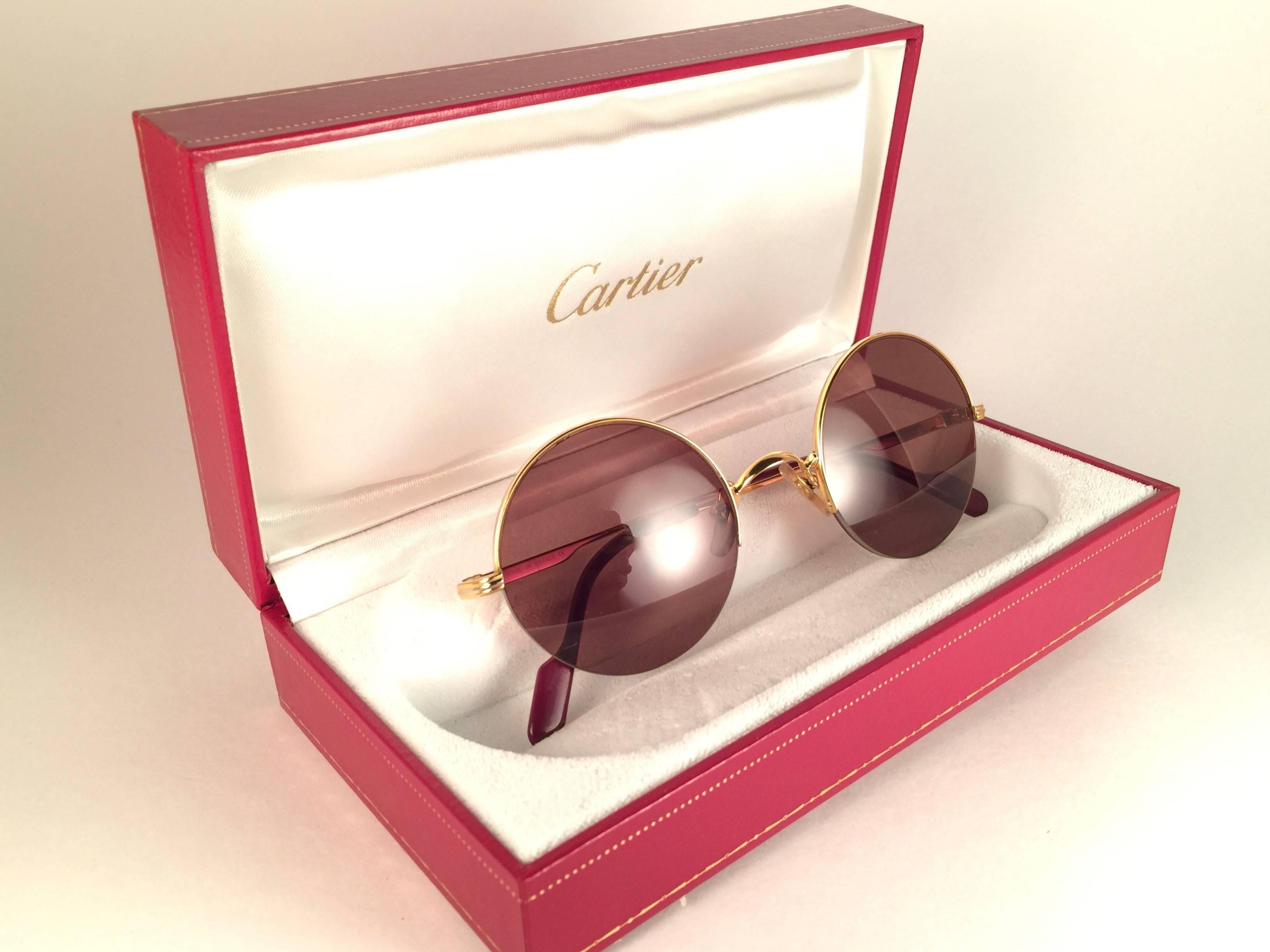  New 1990 Cartier Mayfair half frame sunglasses with brown (uv protection) lenses.  Frame is with the front and sides in gold. All hallmarks. Cartier gold signs on the ear paddles.  These are like a pair of jewels on your nose. Beautiful design and