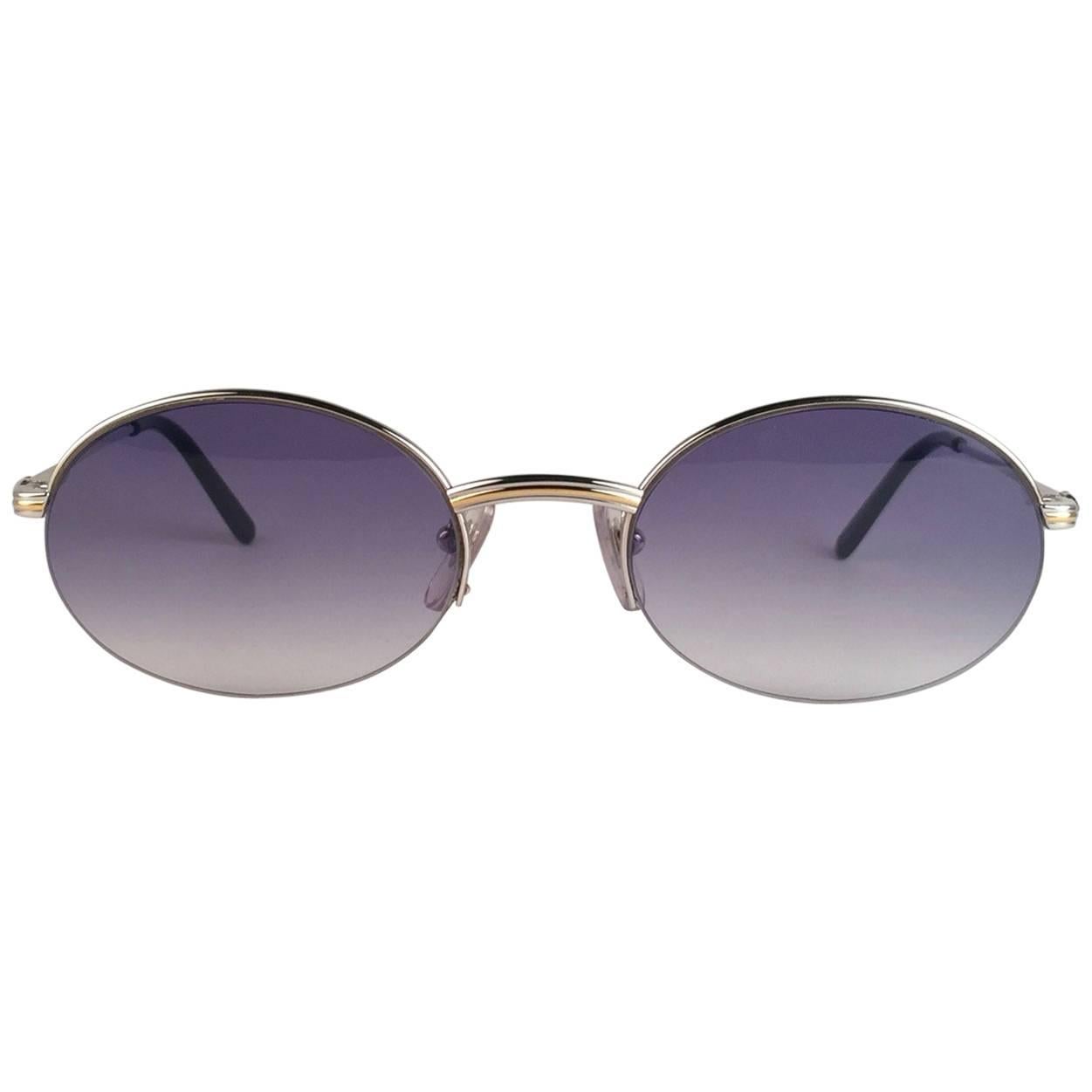 New Cartier oval Manhattan sunglasses with blue gradient lenses(uv protection). All hallmarks. Silver Cartier signs on the ear paddles. 
Both arms sport the knot from Cartier on the temple. These are like a pair of jewels on your nose. 
Beautiful