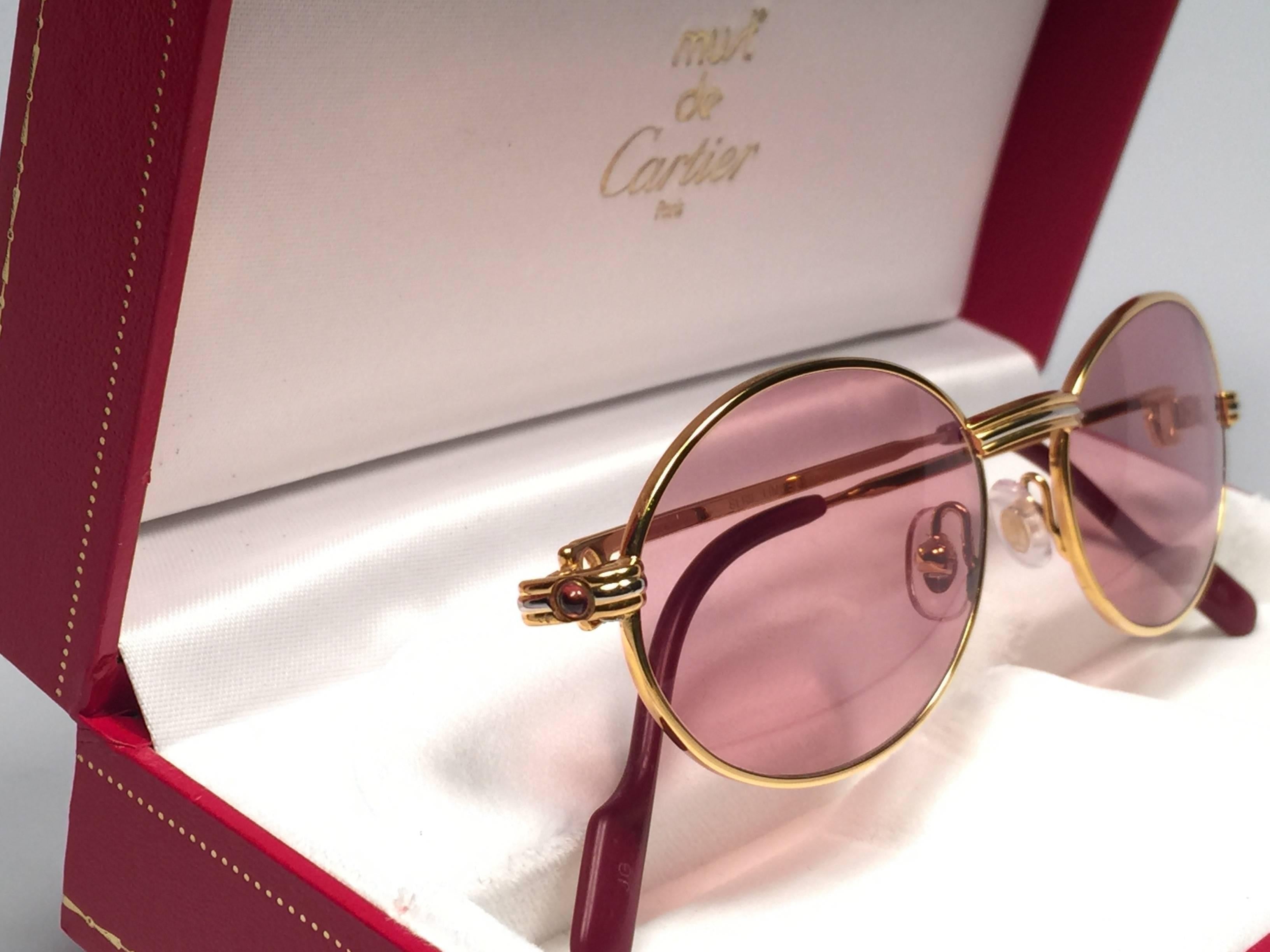New Cartier oval St Honore Limited Series sunglasses adorned with two ruby gemstones on each side.
All hallmarks. Cartier signs on the ear paddles. 
Both arms sport the knot from Cartier on the temple. These are like a pair of jewels on your nose.
