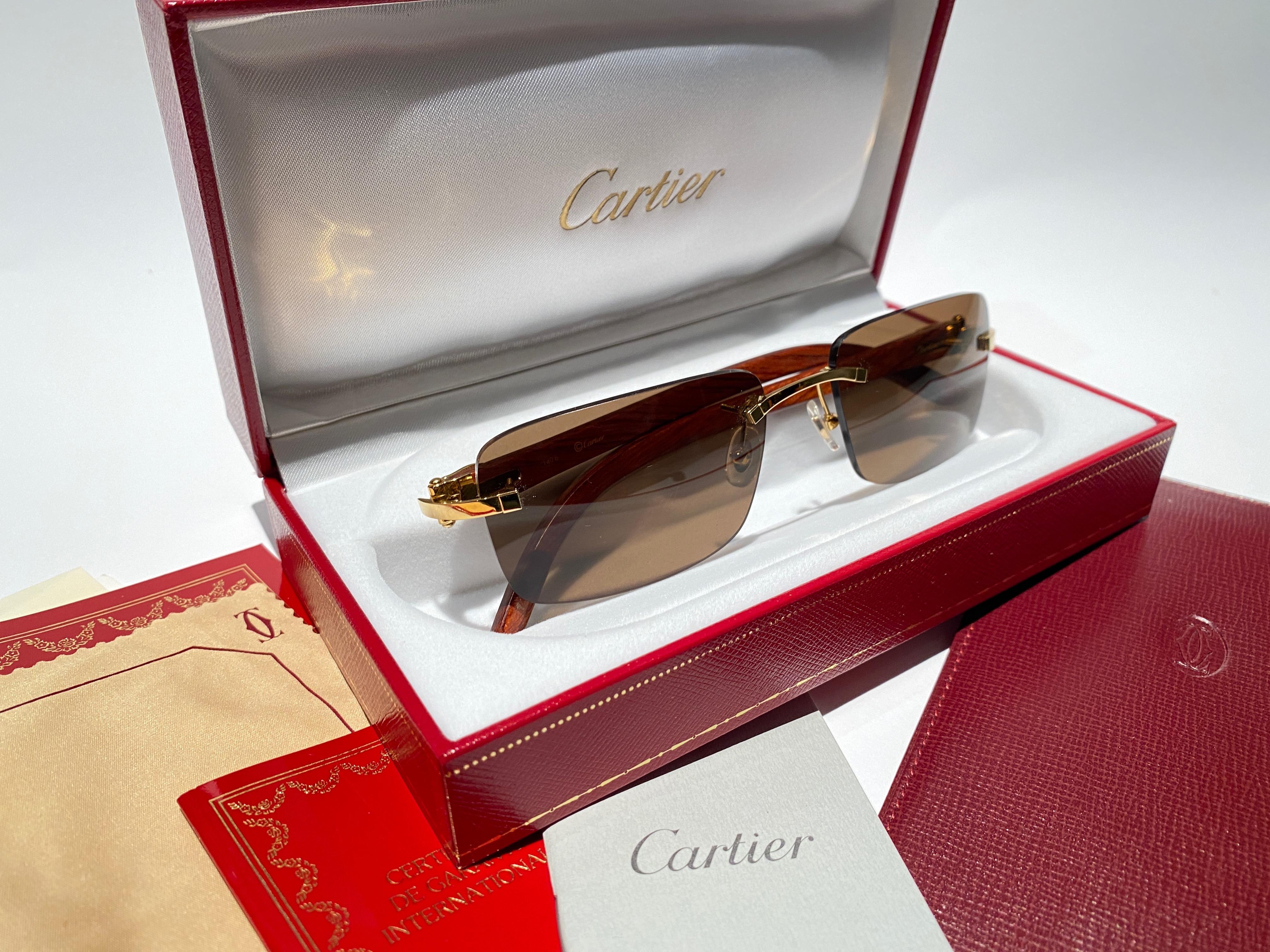 Vintage Original Cartier Sunglasses with monogram wood temples and brown uv protection lenses.  
Frame with the front and sides in gold plated.  
All hallmarks. Cartier signs on the ear paddles. 
Both arms sport the c from Cartier on the temple. 