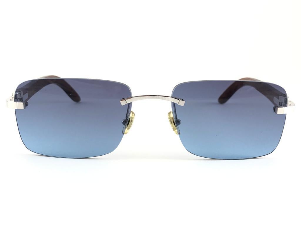 Vintage Original Cartier Sunglasses with zebra carved wood temples and blue gradient uv protection lenses.  
Frame with the front and sides in platine plated.  
All hallmarks. Cartier signs on the ear paddles. 
Both arms sport the c from Cartier on