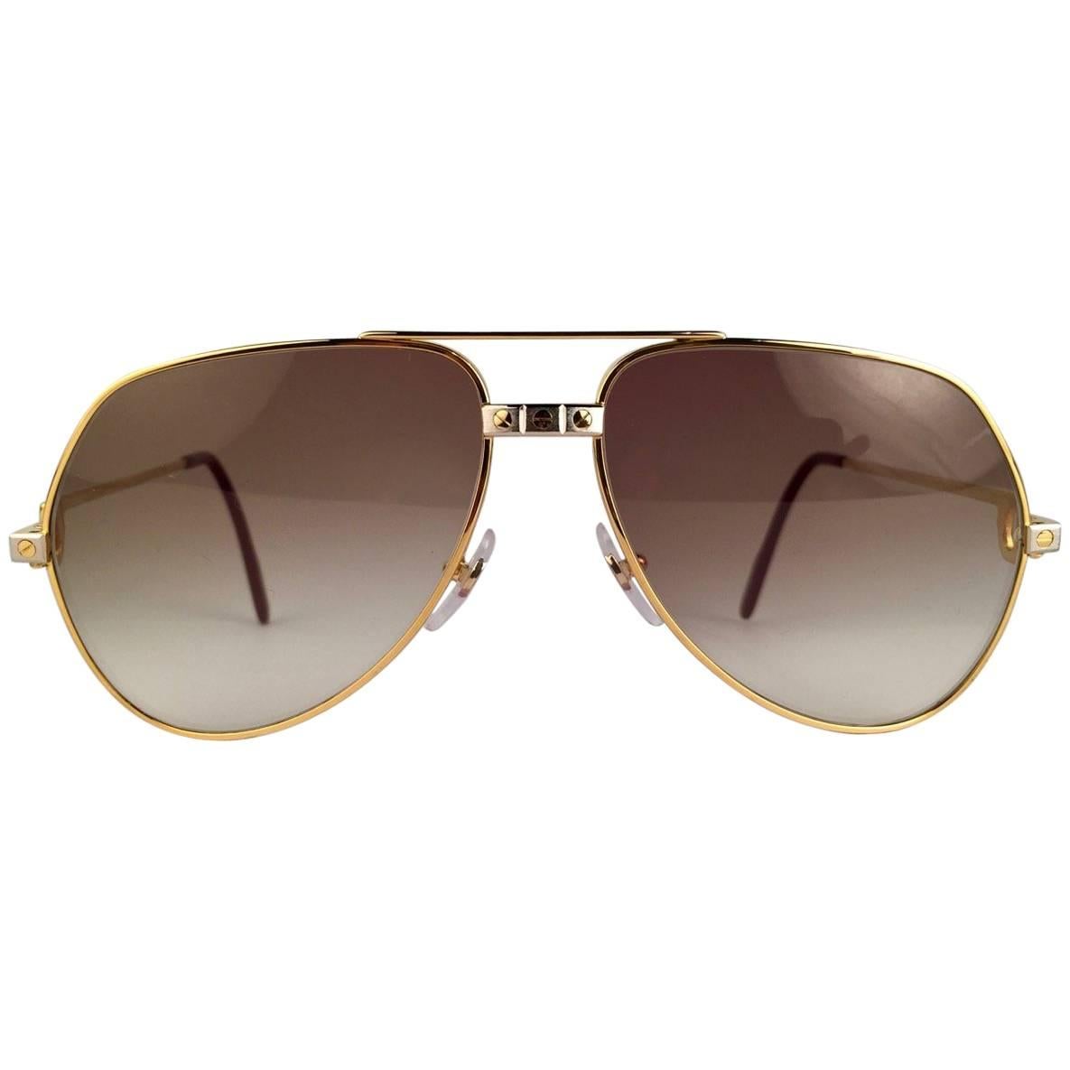 New from 1983!!! Cartier Aviator Santos Sunglasses with Brown Gradient (uv protection) Lenses.  Frame is with the famous screws on the front and sides in yellow and white gold. All hallmarks. Red enamel with Cartier gold signs on the ear paddles. 