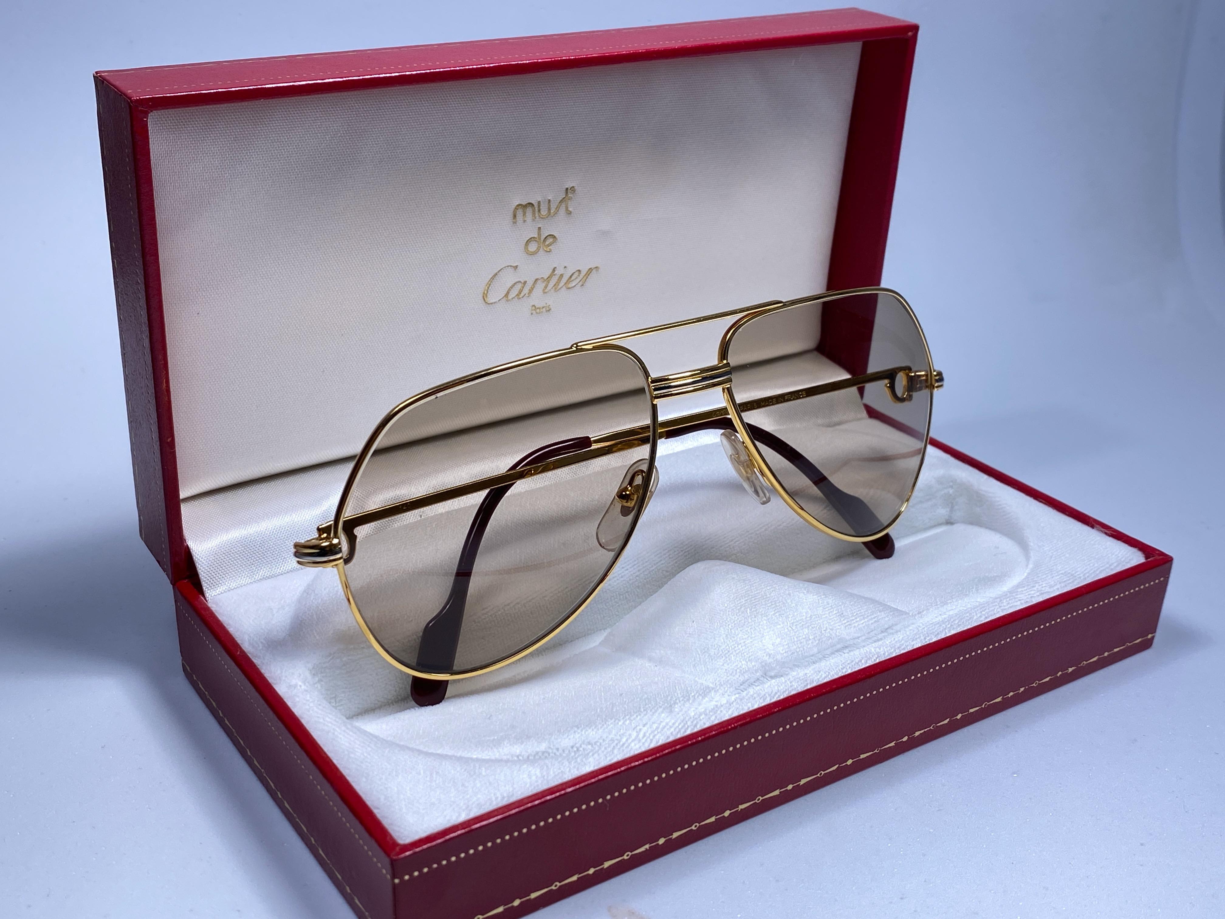 New from 1983!!! Cartier Aviator Vendome 59MM Heavy plated gold sunglasses with light brown  (uv protection) Lenses.  Frame is with the famous Vendome stripes on the front and sides in yellow and white gold. 
All hallmarks. 
Red enamel with Cartier