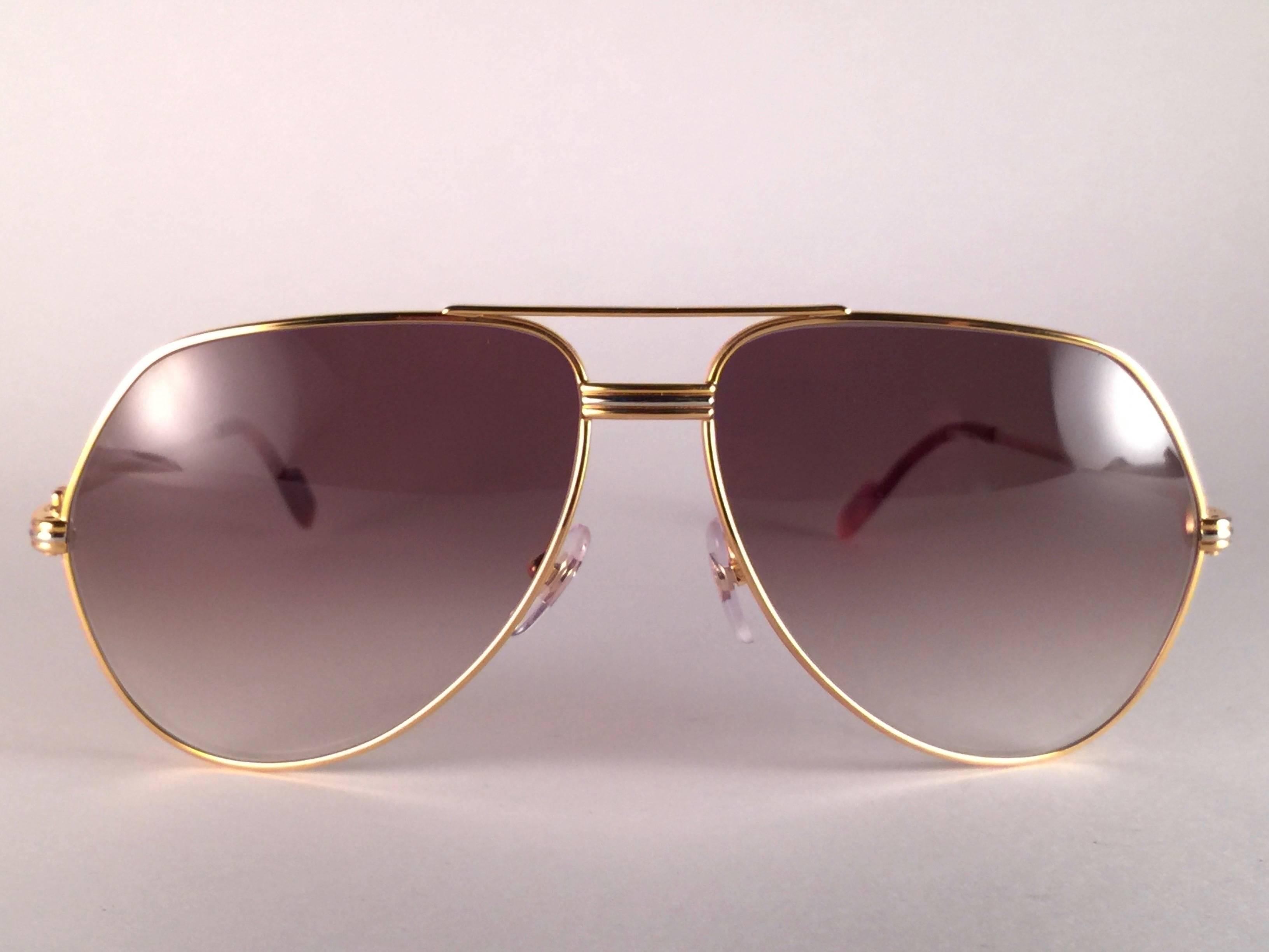 New from 1983!!! Cartier Aviator Vendome 62MM Heavy plated gold sunglasses with brown  (uv protection) Lenses.  Frame is with the famous Vendome stripes on the front and sides in yellow and white gold. 
All hallmarks. 
Red enamel with Cartier gold
