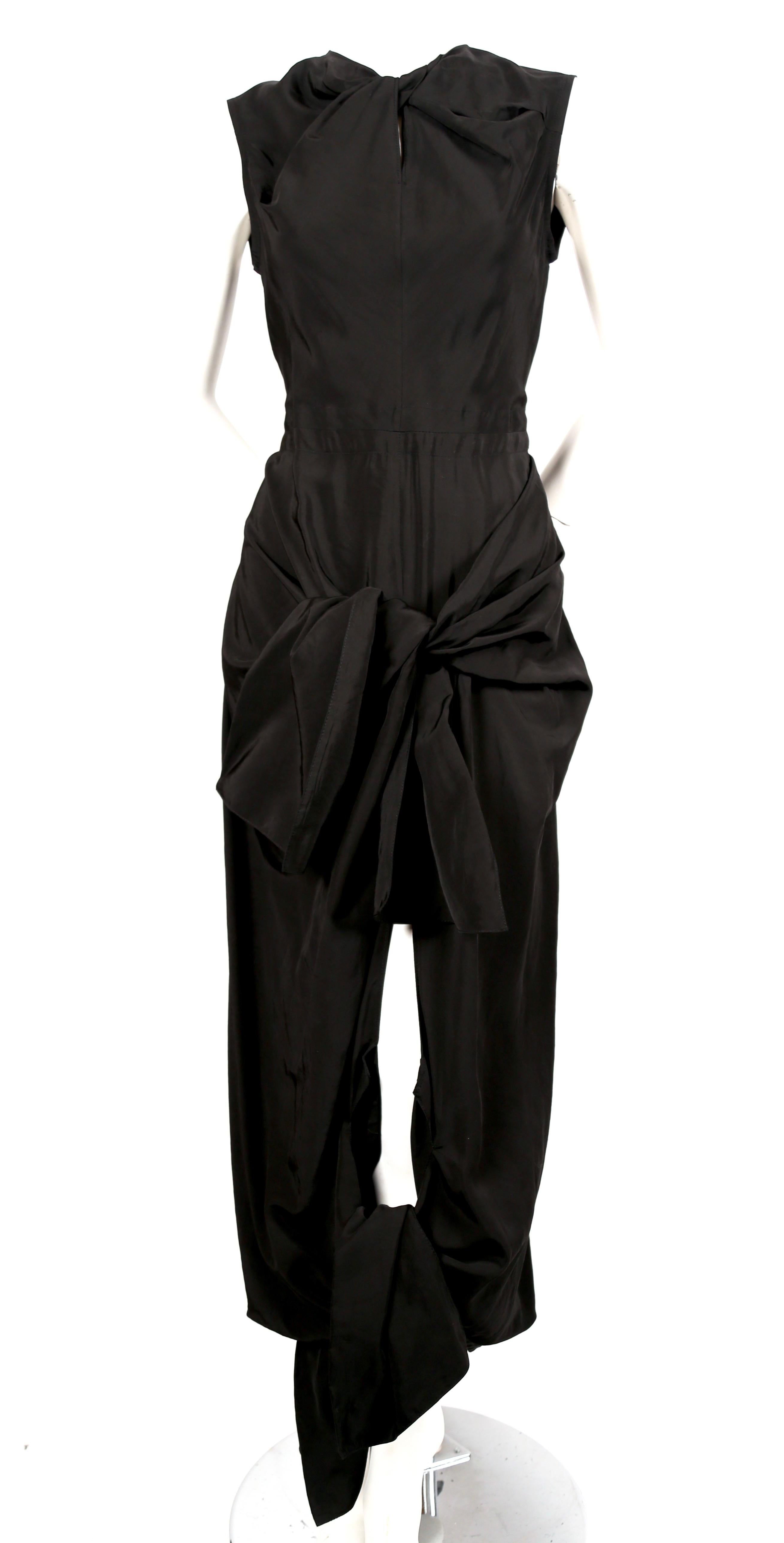 Jet-black dress with twisted neckline, ties at hips and cut out at back designed by Phoebe Philo for Celine. French size 36. Approximate measurements: shoulder 13.75