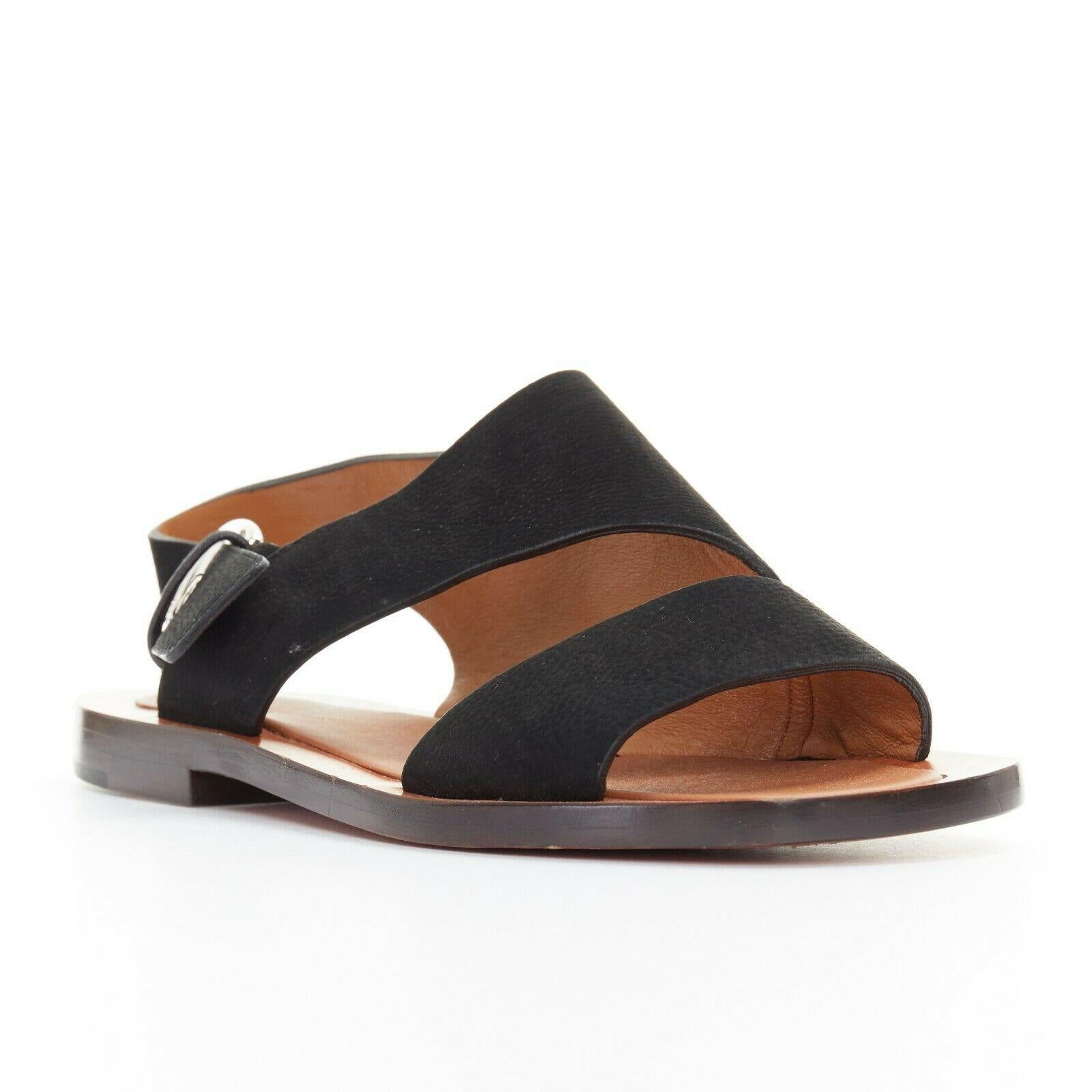 new CELINE PHILO black suede silver buckle sling back flat sandals EU36
CELINE BY PHOEBE PHILO
Black suede leather upper. Open toe. 
Asymmetric cut sandals. Silver-tone hardware. 
Sling back. Buckle closure. Stacked wooden sole. 
Made in