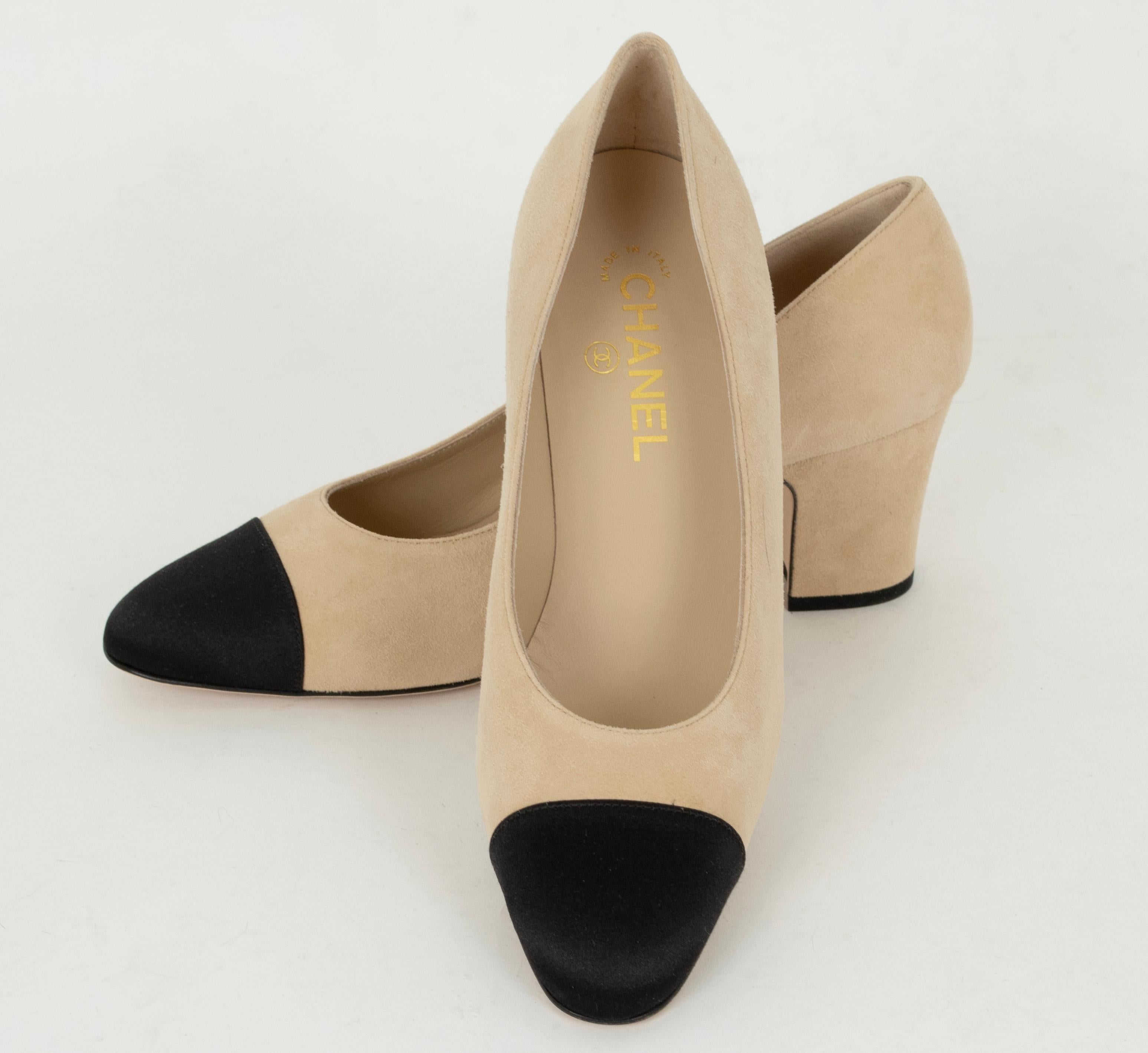 Diese neuen, ungetragenen und nicht mehr produzierten zweifarbigen Pumps sind der Inbegriff des Chanel-Schuhs. Noch eleganter wird der Schuh durch die schwarze Cap-Zehe aus Satin anstelle der traditionellen Ripsbandspitze. Eleganz in