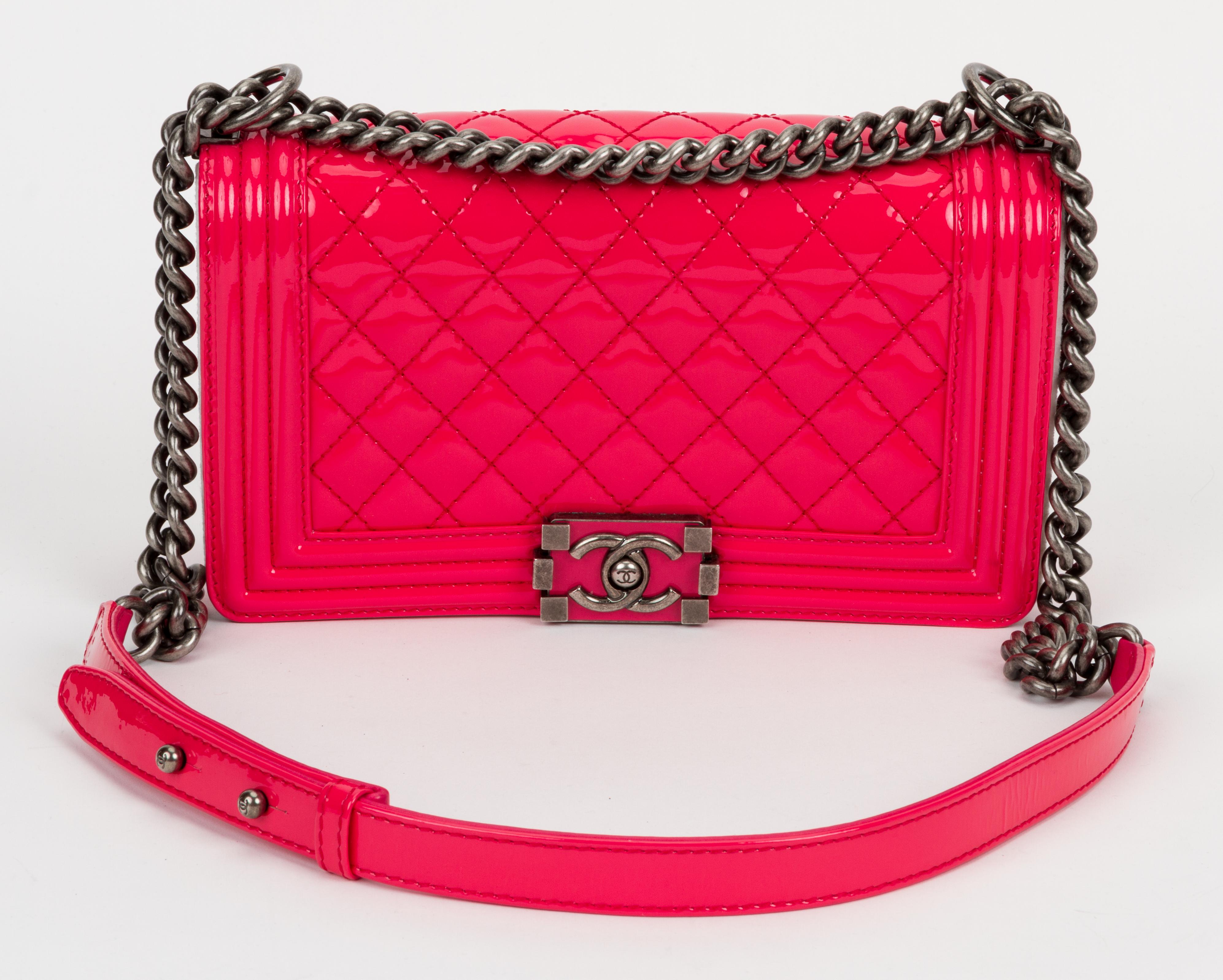 Chanel medium boy bag in hot pink patent leather with matching lambskin lining and ruthenium hardware. Front clasp is enameled. Shoulder drop, 11