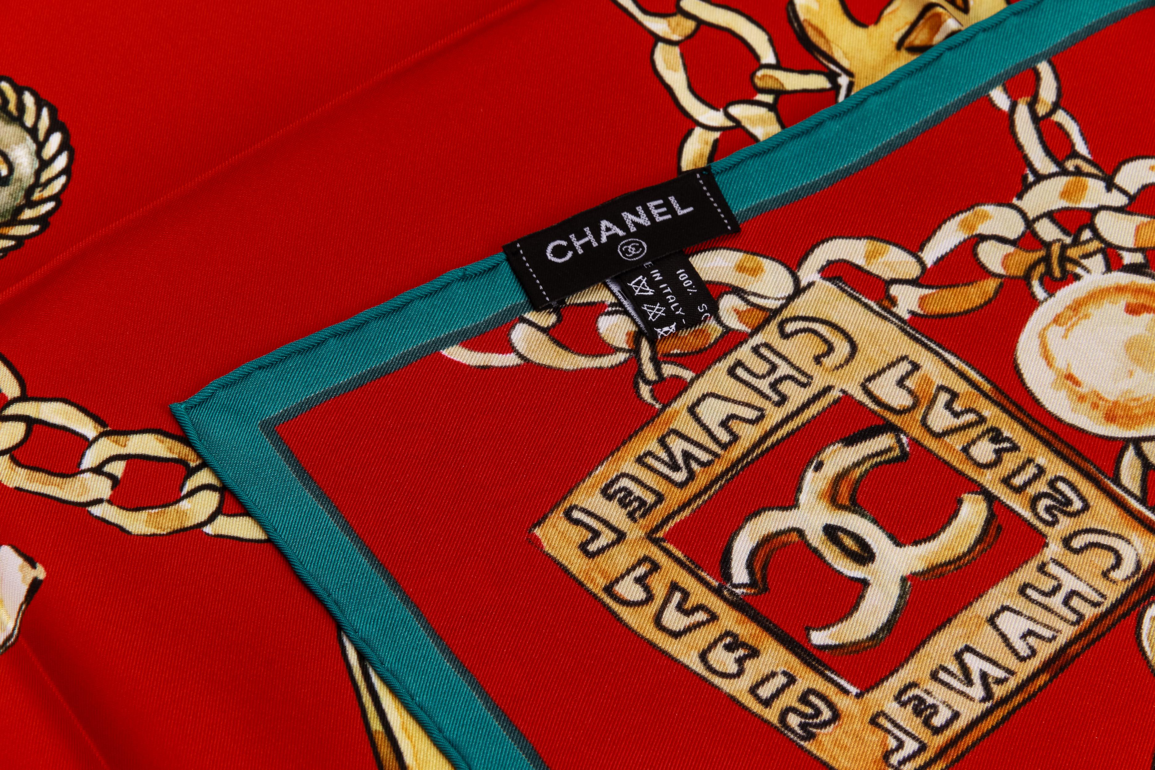 Chanel nouveau foulard 100% soie. Design/One, gripoix et logos iconiques de la bijouterie des années 70. Rouge avec garniture verte. Étiquette d'entretien jointe.
