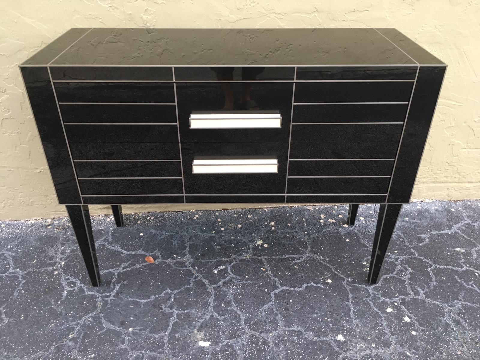 Beautiful and elegant black mirrored commode. 
Spectacular white glass handle.
Two-brake drawers.
Oakwood furniture sheathed glass.
 