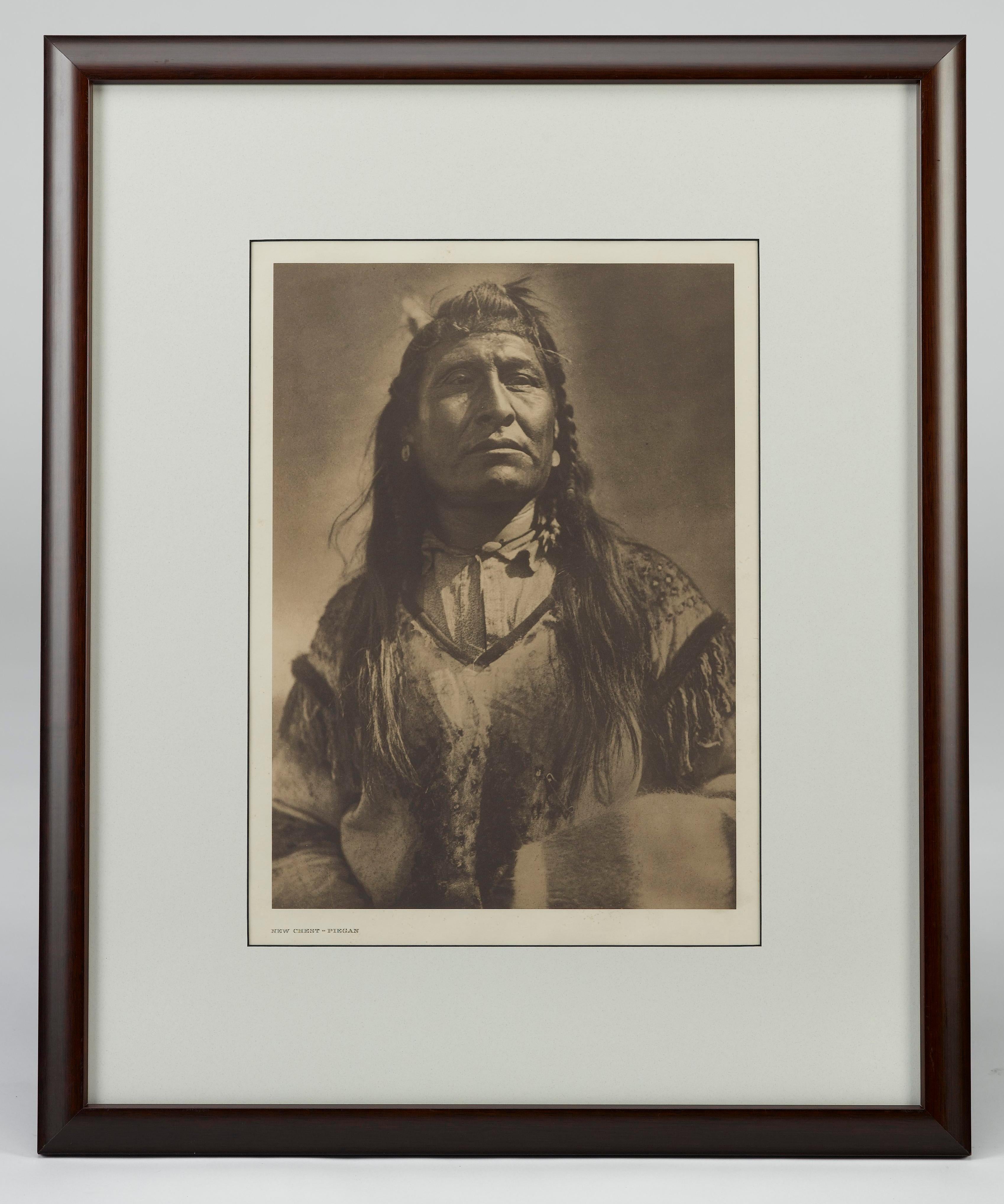 Presented is a fine photogravure portrait of a Piegan man named New Chest by Edward Curtis. The image is Plate 200 from Supplementary Portfolio 6 of Edward Curtis' epic project The North American Indian. The sixth portfolio volume featured the