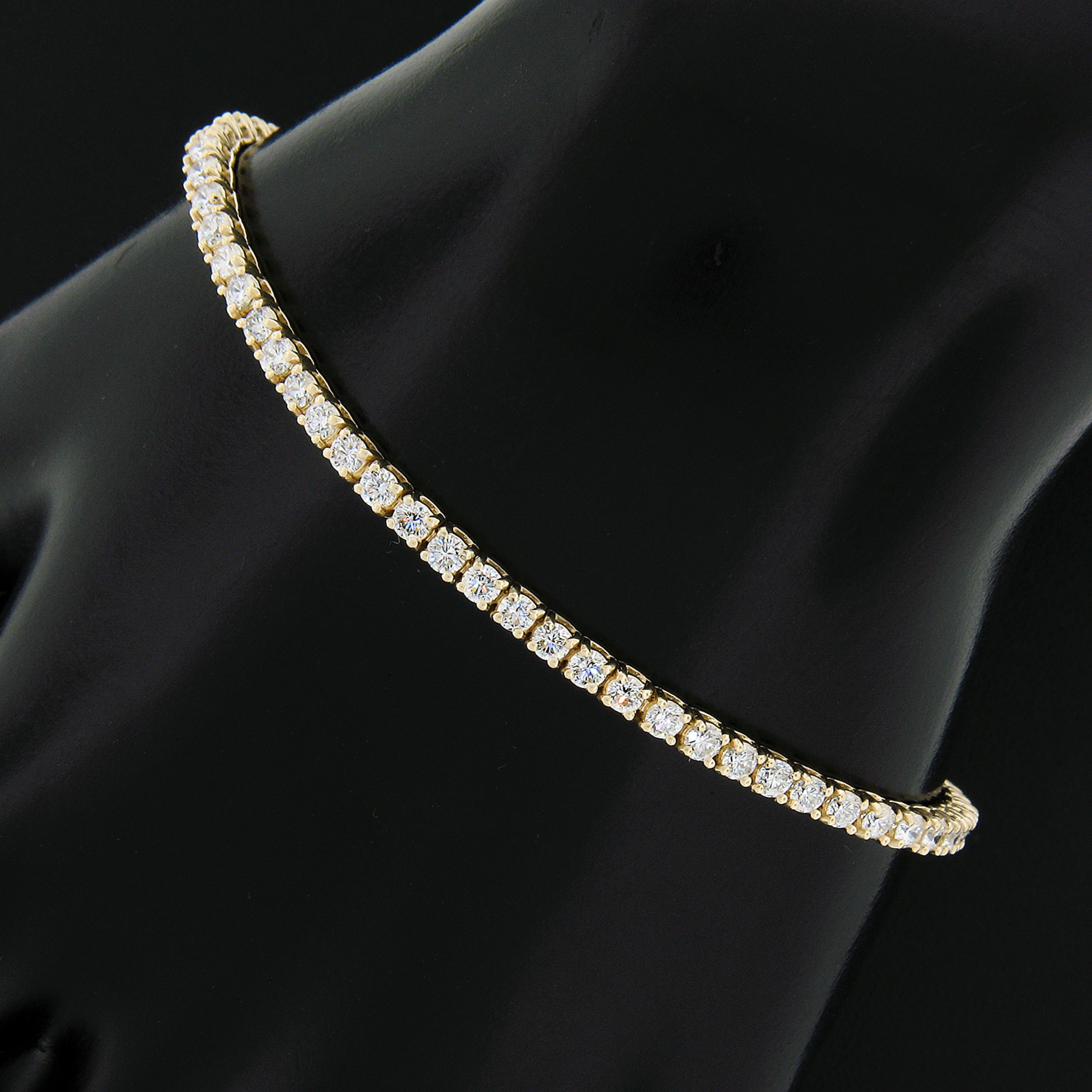 This is a truly breathtaking, classic, diamond line tennis bracelet crafted in solid 14k yellow gold and neatly set with 68 round brilliant cut diamonds throughout. Each diamond sits in a beautiful and sturdy 4-prong basket. These TOP QUALITY