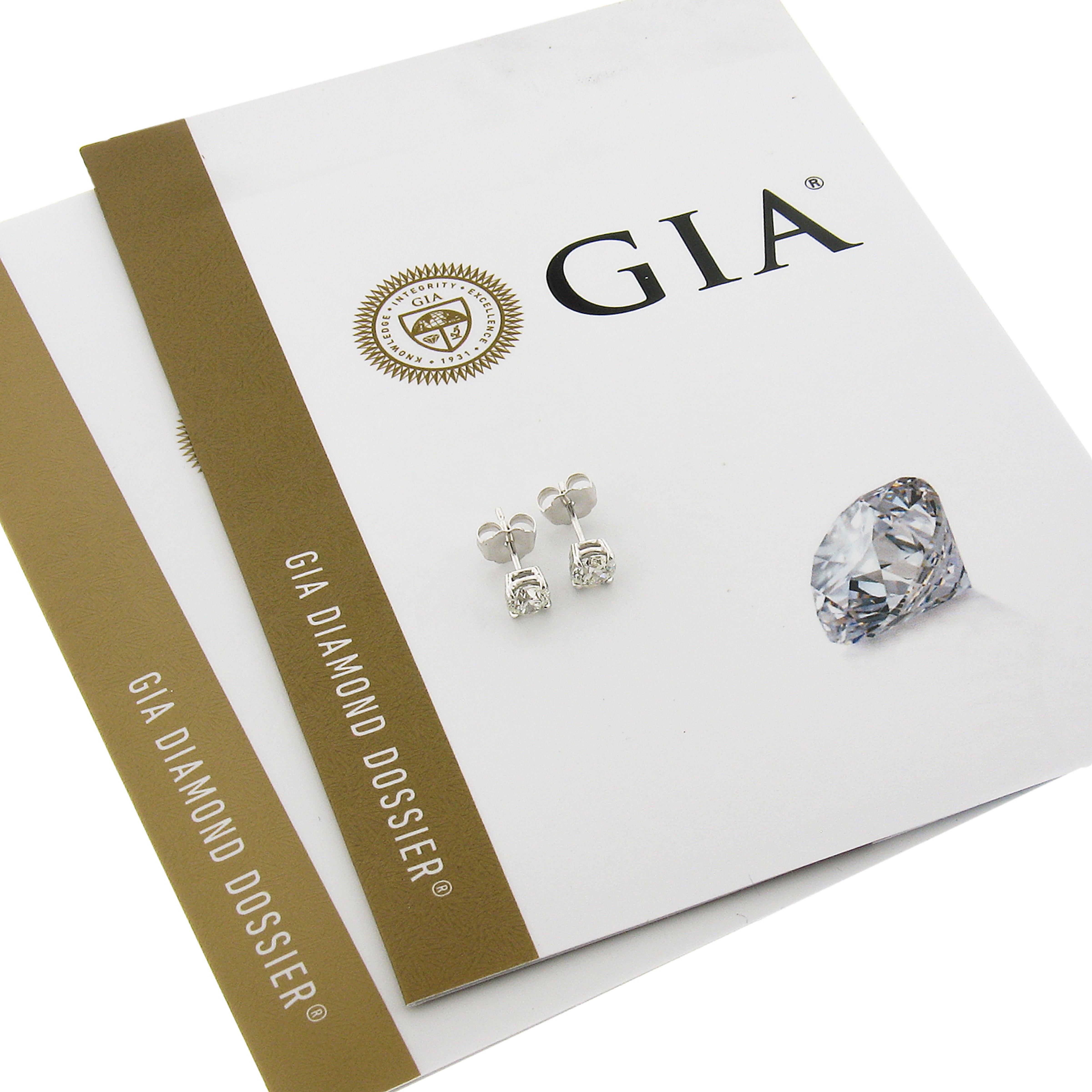 This elegant pair of diamond stud earrings was newly crafted from solid 14k white gold and features two brilliant and fiery, GIA certified round diamonds. These very fine quality diamonds total exactly 0.80 carats in weight and they come with the