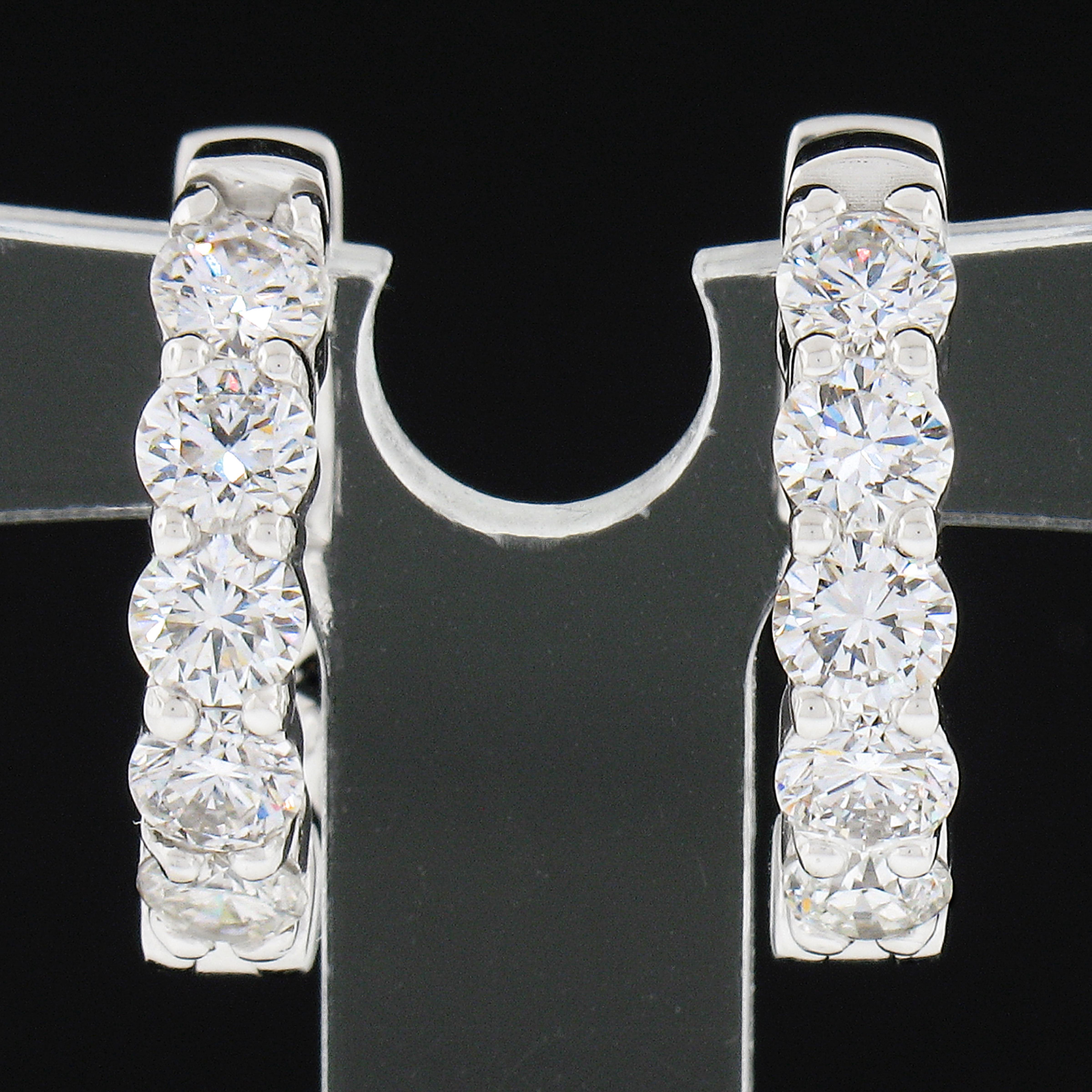 This classic and very well made pair of hoop earrings was newly crafted in solid 14k white gold and features exactly 1.23 carats of round brilliant cut diamonds. These fiery diamonds are neatly shared-prong set across the front side in sets of 5,
